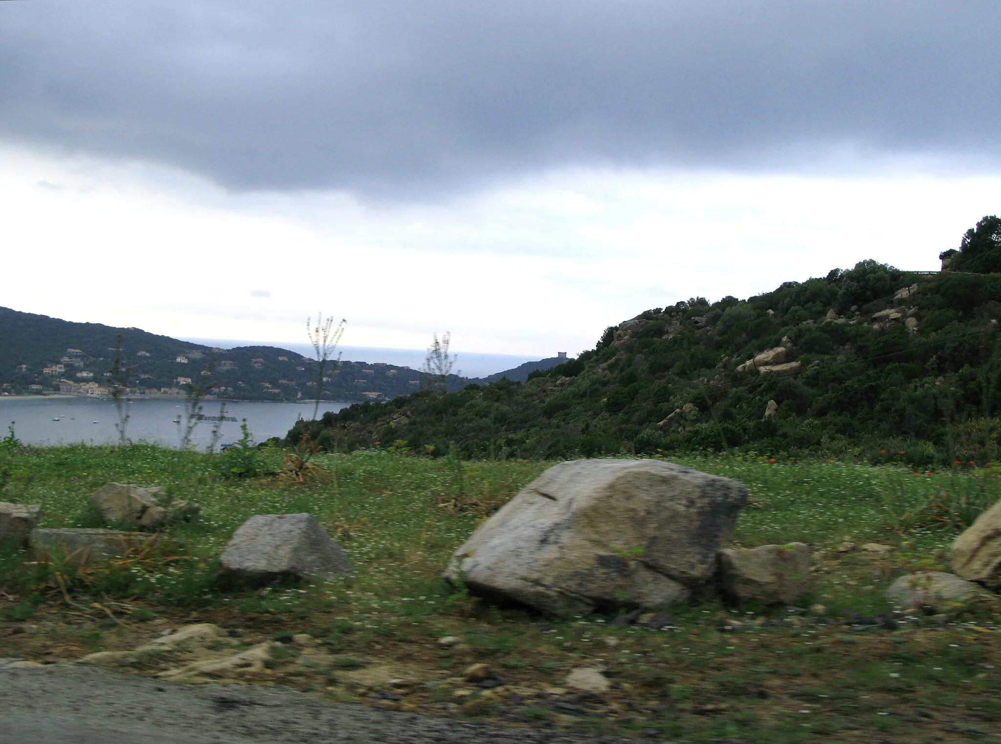 Photo showing: Belvédère-Campomoro (Corse-du-Sud, France)
Le promontoire et la tour génoise de Campomoro, photographiés dans des conditions difficiles : depuis un véhicule en mouvement sur la route départementale D 121 (se dirigeant vers Propriano) et avec des arbres, talus ou autres obstacles surgissant brusquement dans le champ.
La tour génoise est encore un peu visible, sur la ligne oblique du talus, juste au-dessus du plus gros rocher du bas-côté de la route.

Camera location 41° 37′ 51.37″ N, 8° 49′ 35.66″ E View this and other nearby images on: OpenStreetMap 41.630937;    8.826571