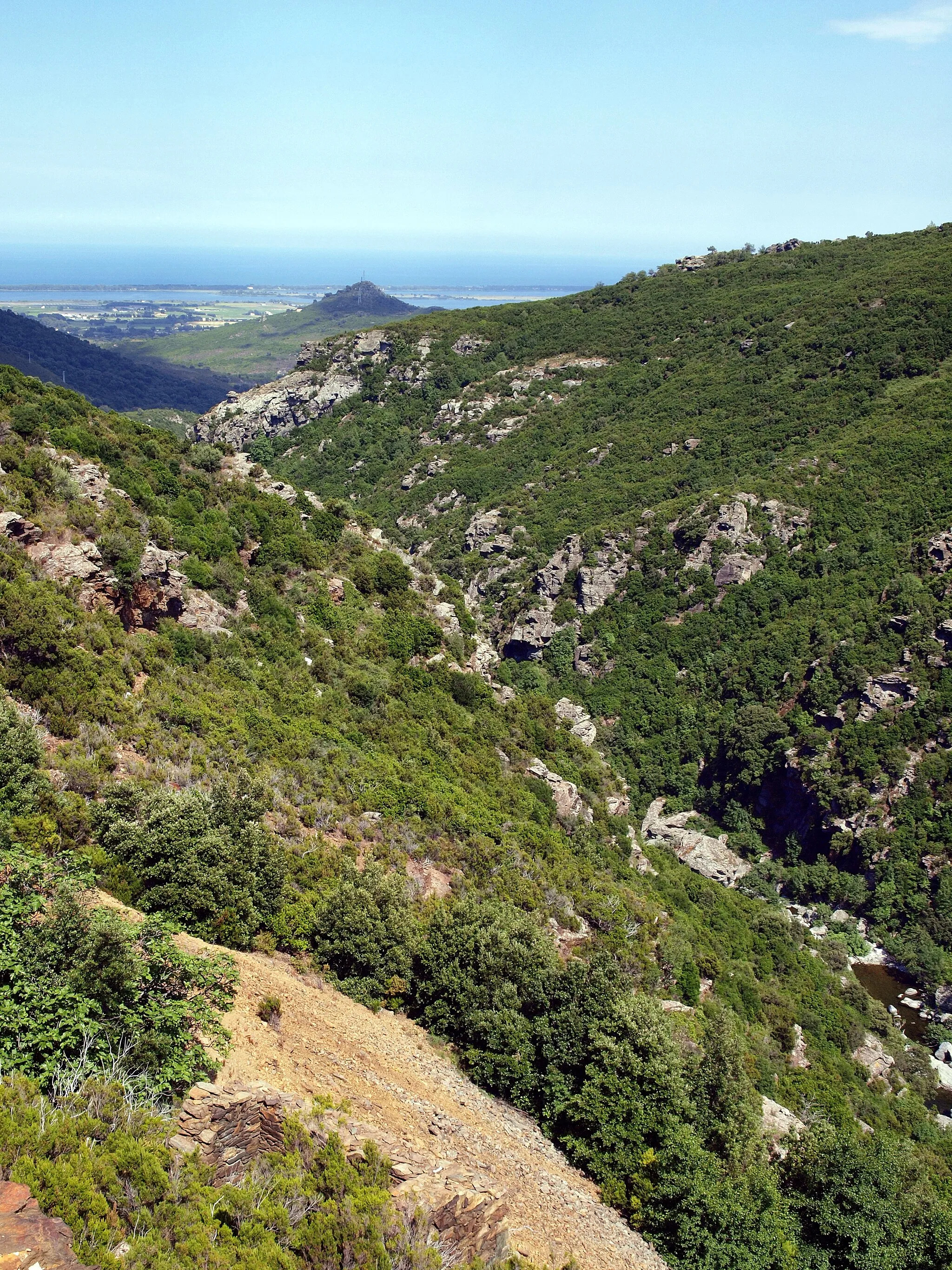 Photo showing: Rutali, Nebbio (Corse) - Le Bevinco en aval du défilé de Lancone, séparant Olmeta-di-Tuda à gauche, de Rutali à droite. Au bout de celui-ci, le Monte Grosso (191 m), colline dominant la plaine de la Marana et l'étang de Biguglia.