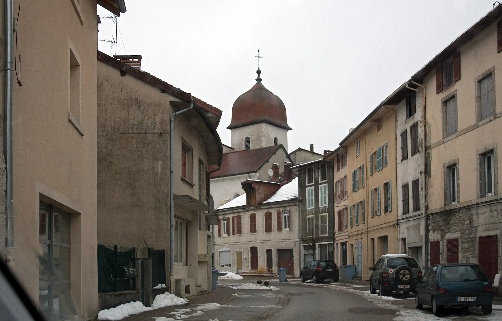 Photo showing: View of Rue Pasteur in Moirans-en-Montagne (Jura Department, France) in winter with the Saint Nicolas Church in the background, taken from car driving North