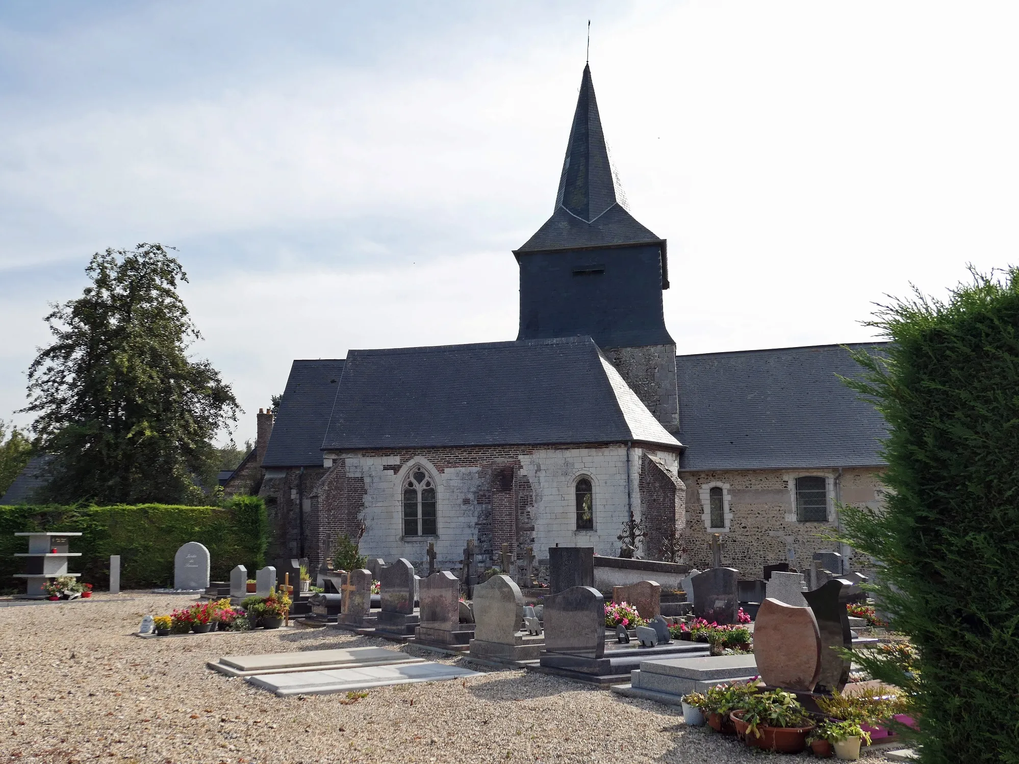 Photo showing: église en croix latine avec chapelles latérales en pierre, moellon et silex.. Tour clocher du 12ème siècle à la croisée du transept couverte d'une flèche polygonale à double pente en ardoise.