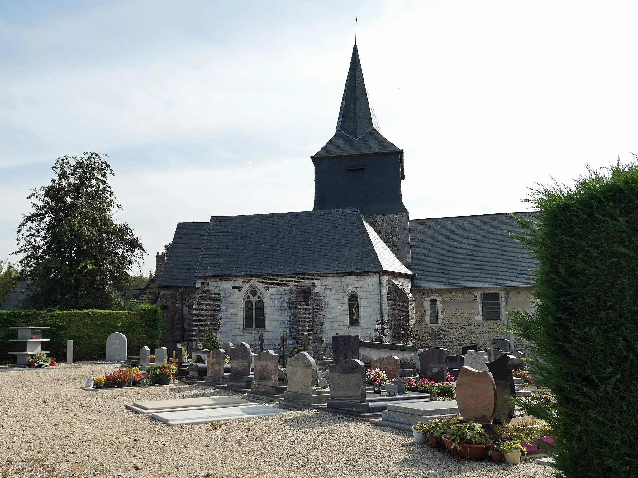 Photo showing: église en briques et pierres entourée du cimetière