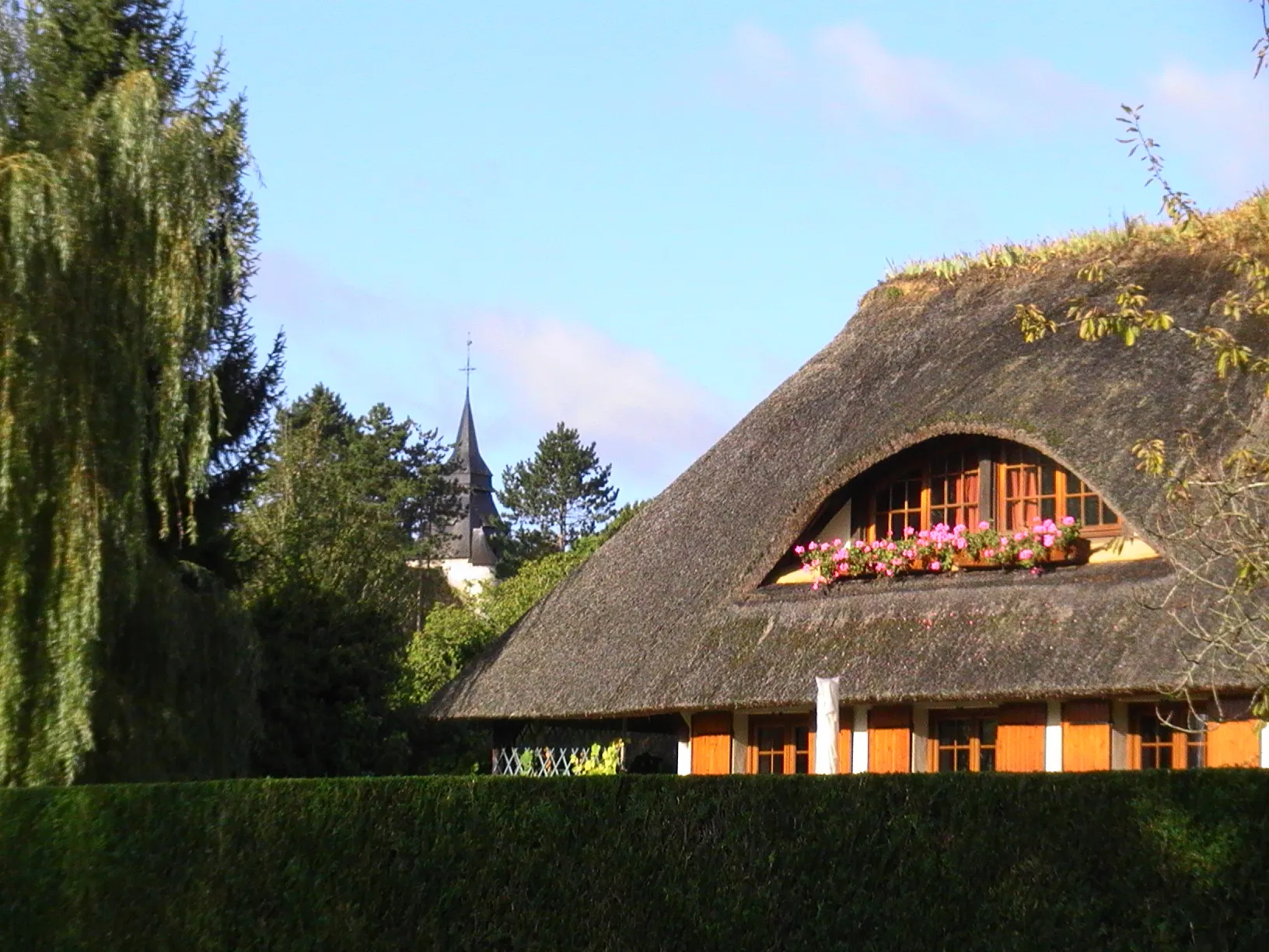 Photo showing: Maison à toit de chaume en bordure de Seine à Tosny. L'église Saint-Sulpice au loin.