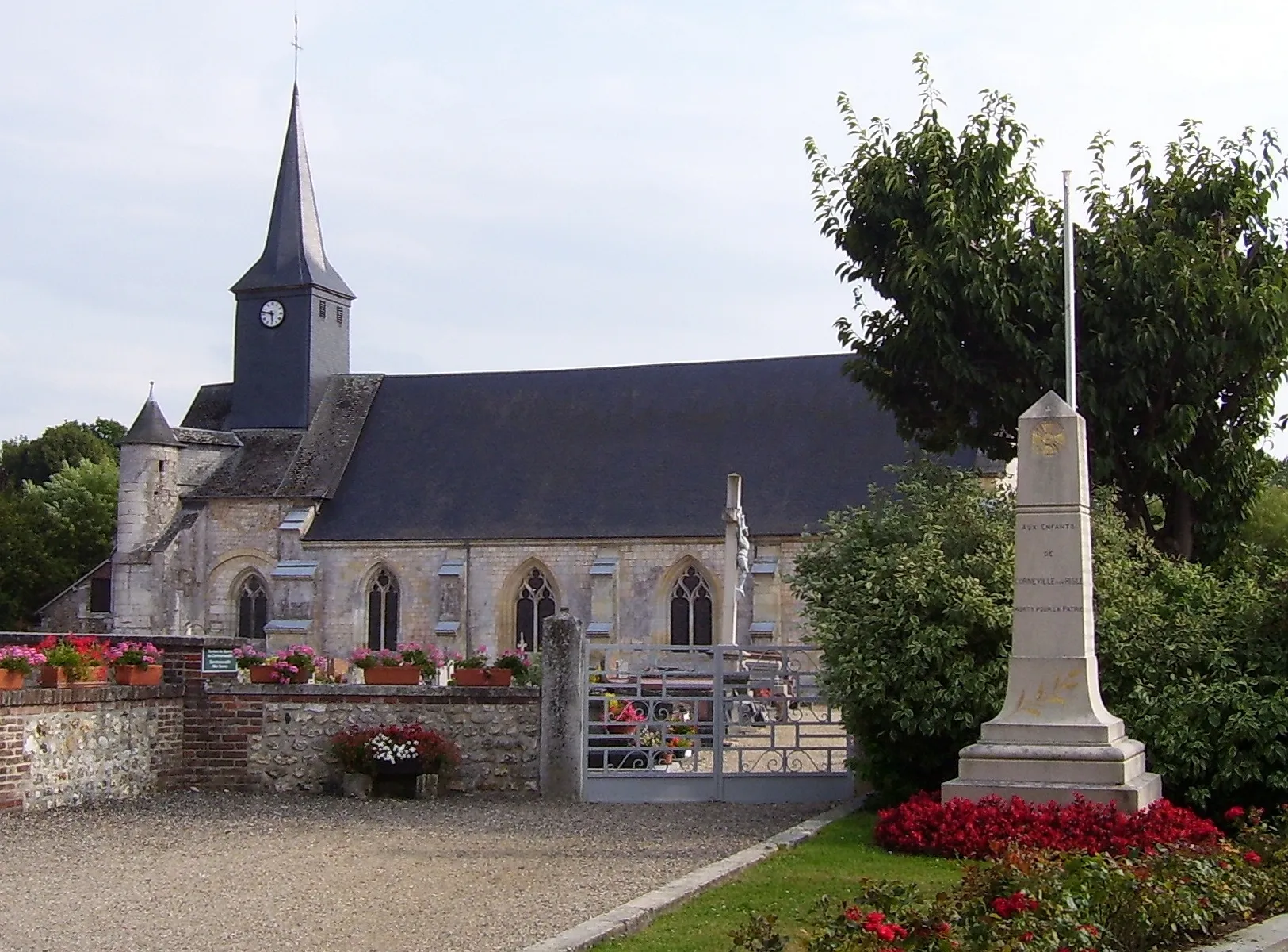 Photo showing: Abbeychurch Notre-Dame in Corneville-sur-Risle, departement Eure, Normandie, France. It was built in the 12th century. And the war memorial of the town.