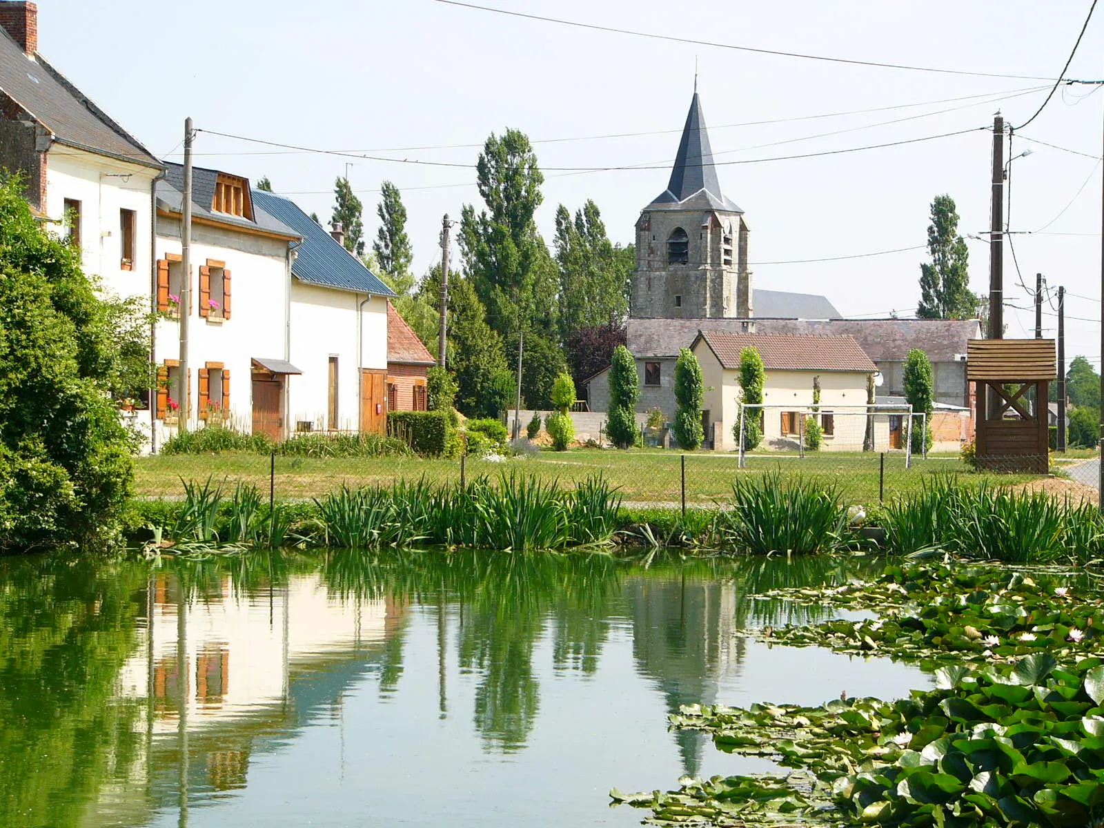 Photo showing: LAVACQUERIE : Vue de la mare de la rue principale, vers l'église