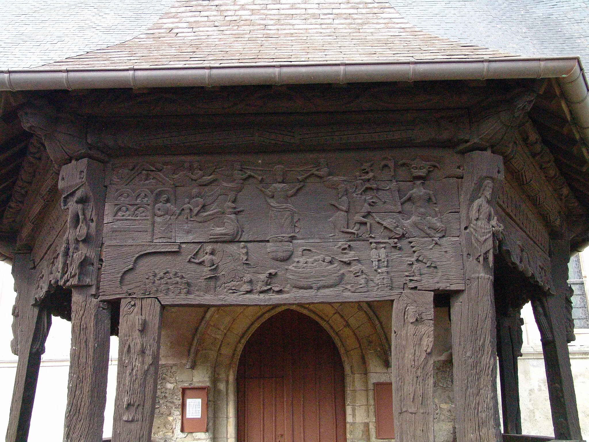Photo showing: Vue des sculptures sur le porche en bois de l'église.