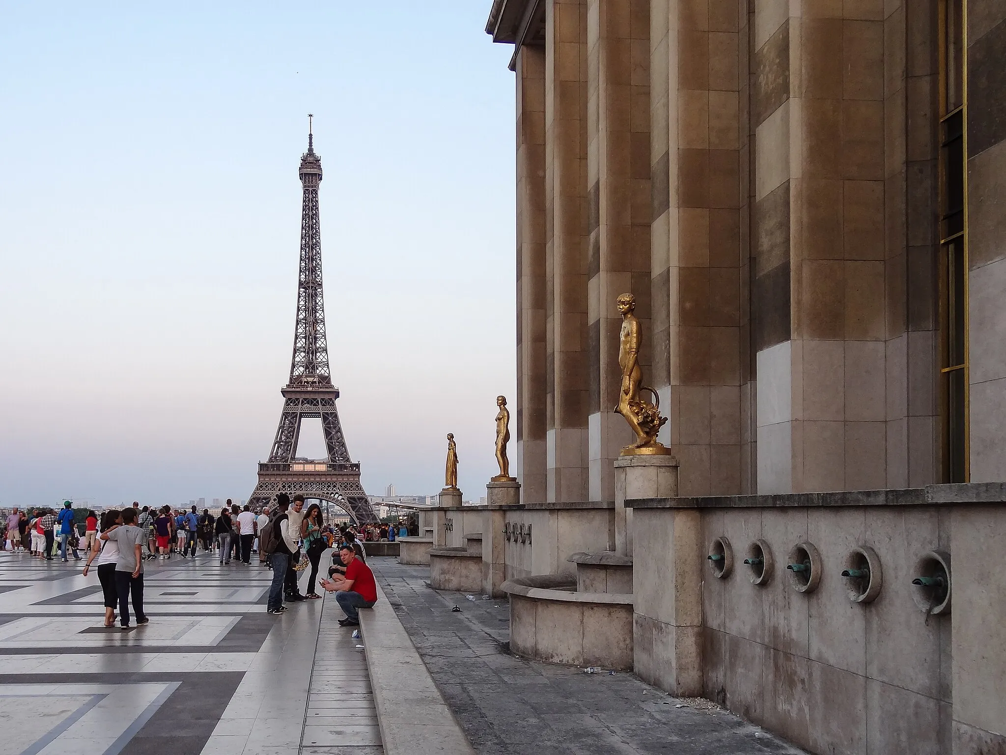 Photo showing: A view from the Palais Chaillot, with multiple golden statues on the terrace, and the Eiffel Tower in view a short distance away.