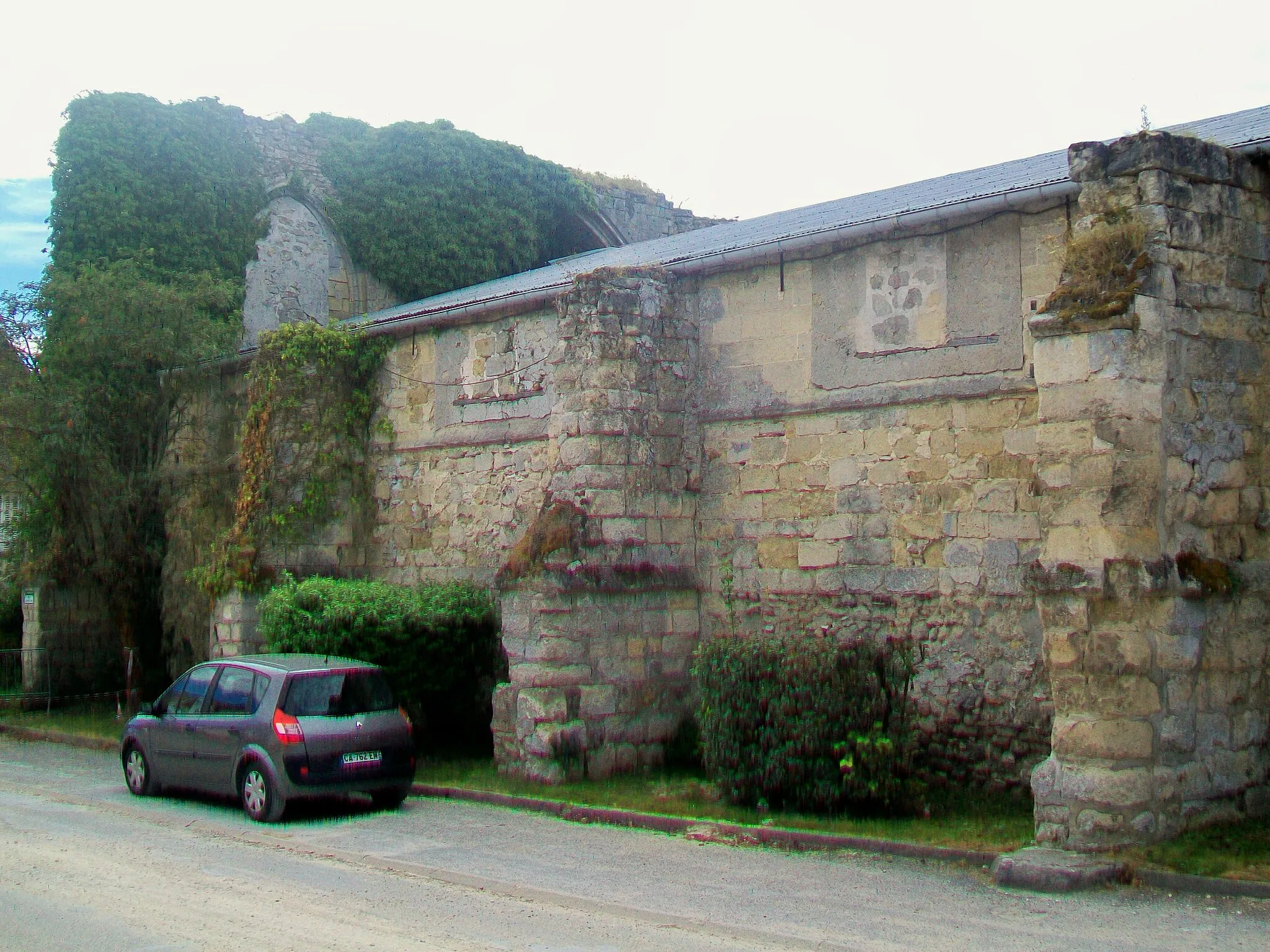 Photo showing: Ruine de l'église XVe siècle du prieuré Sainte-Opportune, rue Jeanne-d'Arc : subsistent le chevet, dont les grandes baies disparaissent sous les lierres, et la partie inférieure de la façade nord. Un hangar agricole moderne occupe l'emplacement de l'église. Le prieuré était rattaché au prieuré Saint-Martin-des-Champs de Paris.