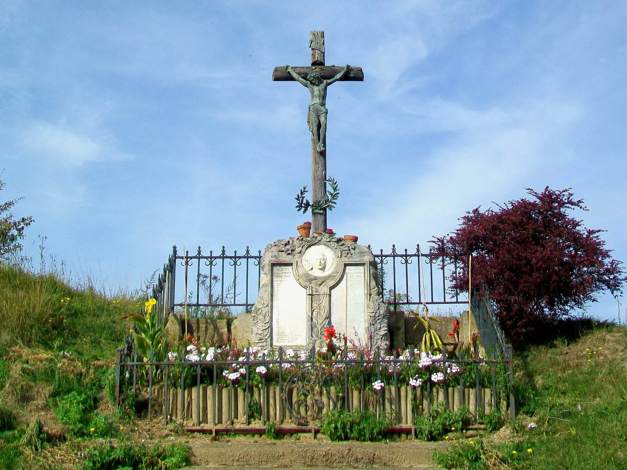 Photo showing: La croix Saint-Justin avec monument aux morts ; à la sortie sud du bourg, rue de Paris, au carrefour avec la RD 317 (ancienne RN 17).