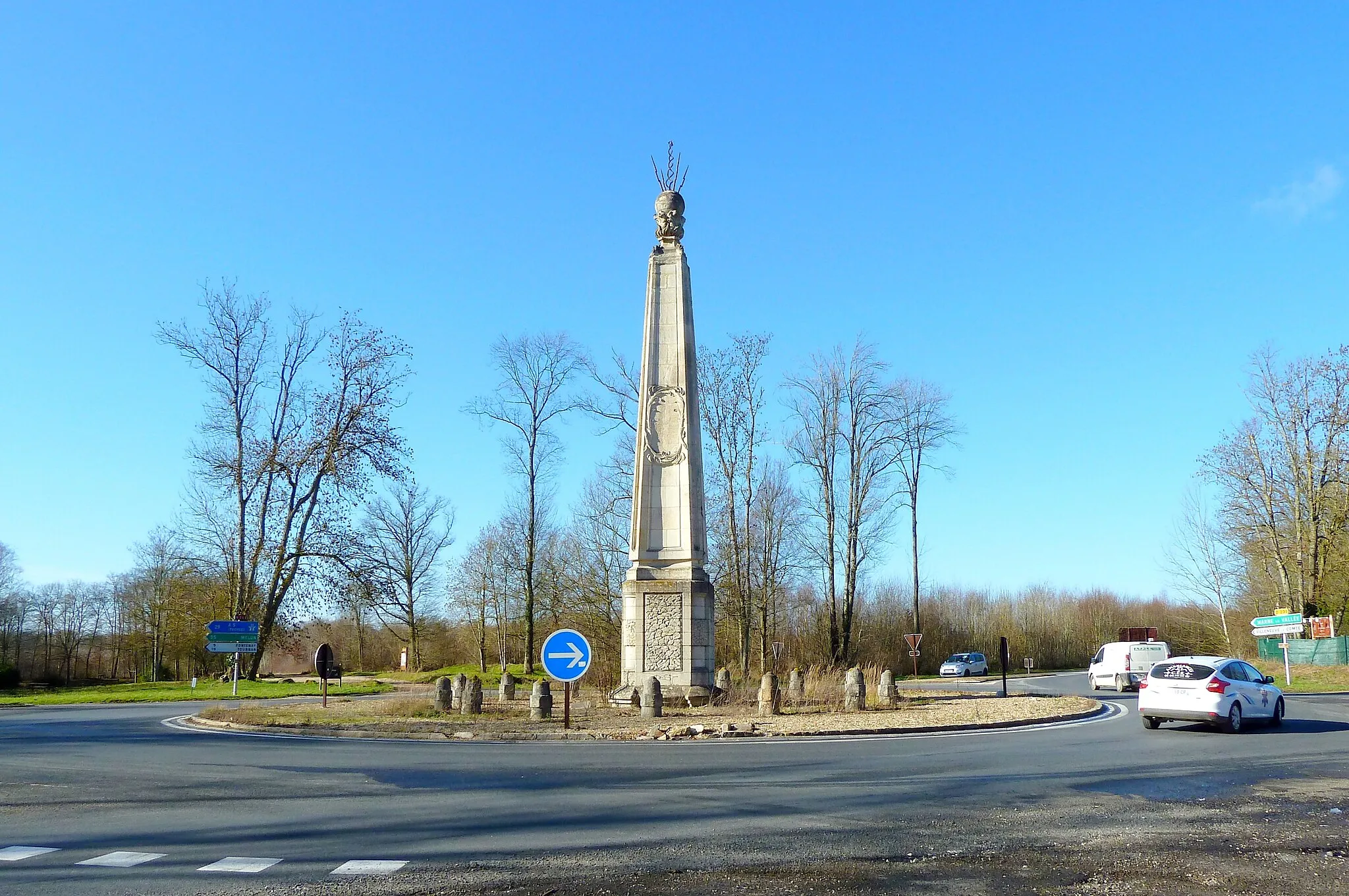 Photo showing: Villeneuve-le-Comte (77), Carrefour de l'Obélisque : carrefour formant une étoile à 6 branches parfaitement régulière, situé au milieu de la Forêt Domaniale de Crécy (Crécy-la-Chapelle) dont il constitue le point culminant, à 134 mètres, formé par la RN 36 (reliant Melun à Meaux, ancienne voie romaine), la RD 231 (depuis 1933, anciennement RD 31, reliant Lagny-sur-Marne à Provins, ancienne voie romaine, partant du camp romain situé à l'est de l'actuel Villeneuve-le-Comte) et la Route pavée (ancienne voie romaine reliant Neufmoutiers à Sainte-Avoye) où passe le Sentier de grande randonnée 14 (De Paris à Malmedy – « Sentier de l'Ardenne ») - Il se trouve en limite de 3 communes : Villeneuve-le-Comte, Mortcerf et Dammartin-sur-Tigeaux - Monument Historique, Fiche Mérimée : PA00087324, classement par arrêté du 1er octobre 1921 - Ouvrage d'art construit au XVIIIe siècle (1735) pour commémorer la rencontre de Louis XV et du Duc de Brandebourg dans le rendez-vous de chasse situé à proximité. Le bas-relief qui était sculpté sur cette face orientée vers l'est, dans le médaillon (représentant un symbole royal, sceptre ou main de justice?) a été vandalisé à la Révolution. La colonne mesure environ 14 mètres de haut, surmontée d'un globe terrestre submergé par les vagues et frappé par des éclairs de foudre et elle est entourée d'un cercle de 15 bornes. Ce monument est référencé dans un ouvrage publié en 1930 par Fulcaneli, intitulé: « les demeures philosophales ». Selon lui, ce serait un monument porteur d’une terrible symbolique (la destruction du monde par l'eau et le feu), un monument essentiel pour les amateurs d’ésotérisme et passionnés d’alchimie.