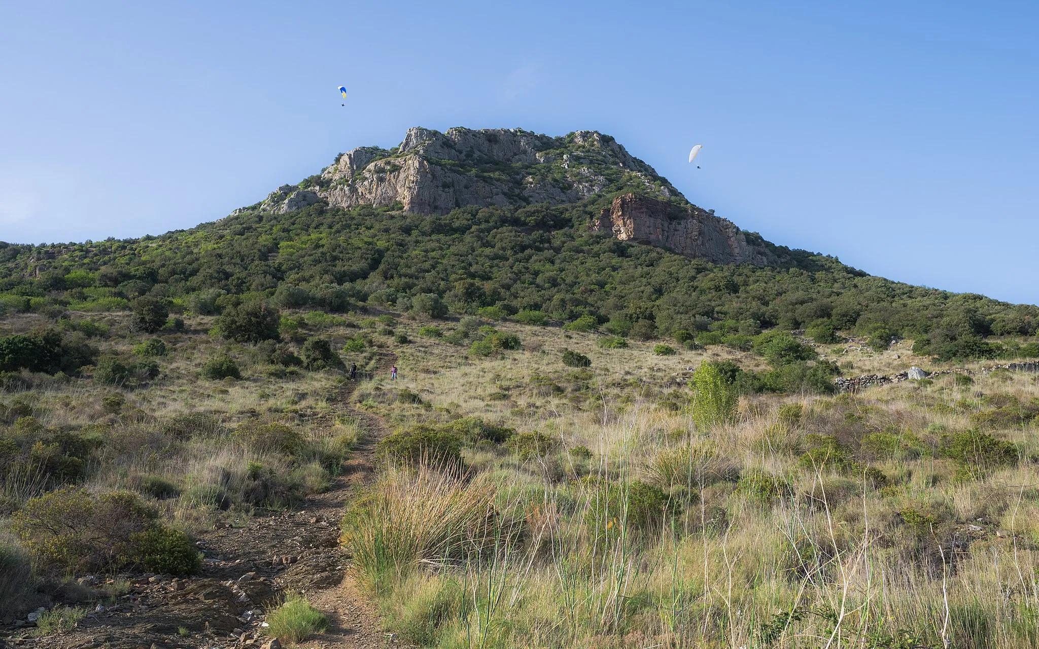 Photo showing: The Pic de Vissou (480m) seen from South and two paragliders. The place is known for the practice of paragliding and of ridge lift. Place : Cabrières, Hérault, France.