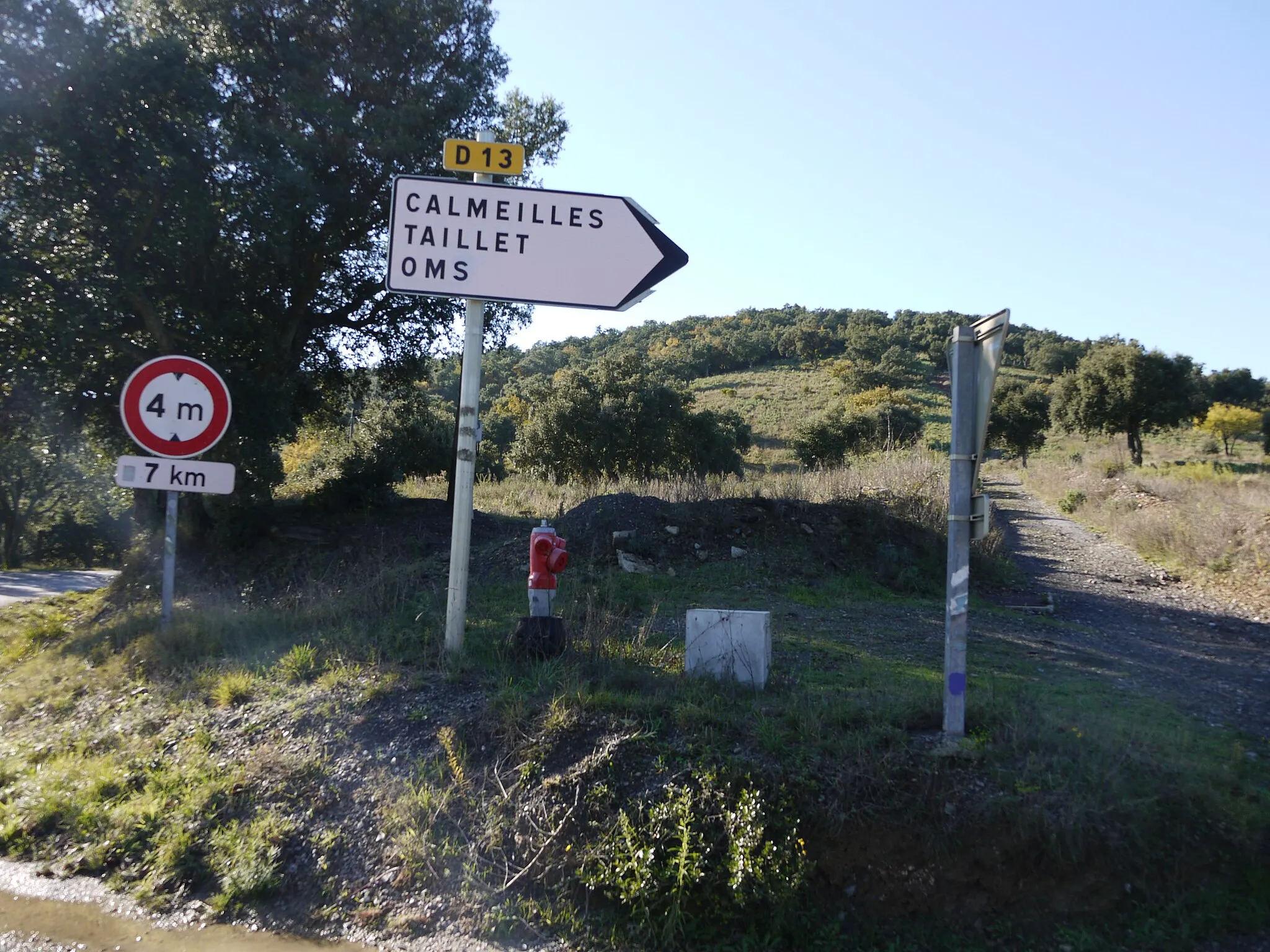 Photo showing: Panneau au Col de Llauro indiquant la route D13 en direction d'Oms, Taillet et Calmeilles, avec panneau B12 (hauteur 4 m maximum) et borne d'incendie.