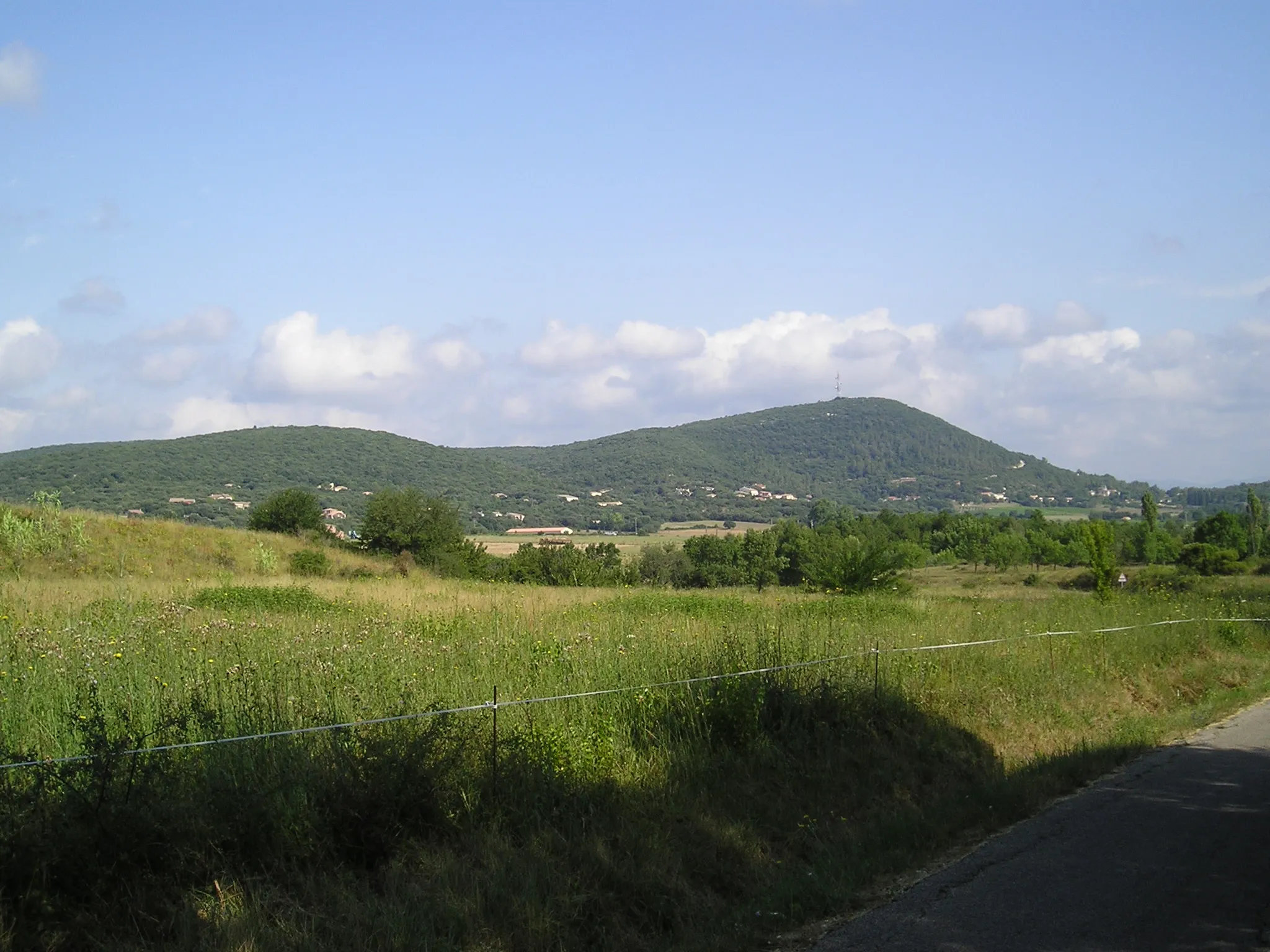 Photo showing: In Western part of La Boissière (Hérault), the main summit of the commune, the Puech Bartelié, 367 meters and its telecommunication tower. At its feet, houses and little appartment-house who are lining up to the main village (hidden on the right, north direction).