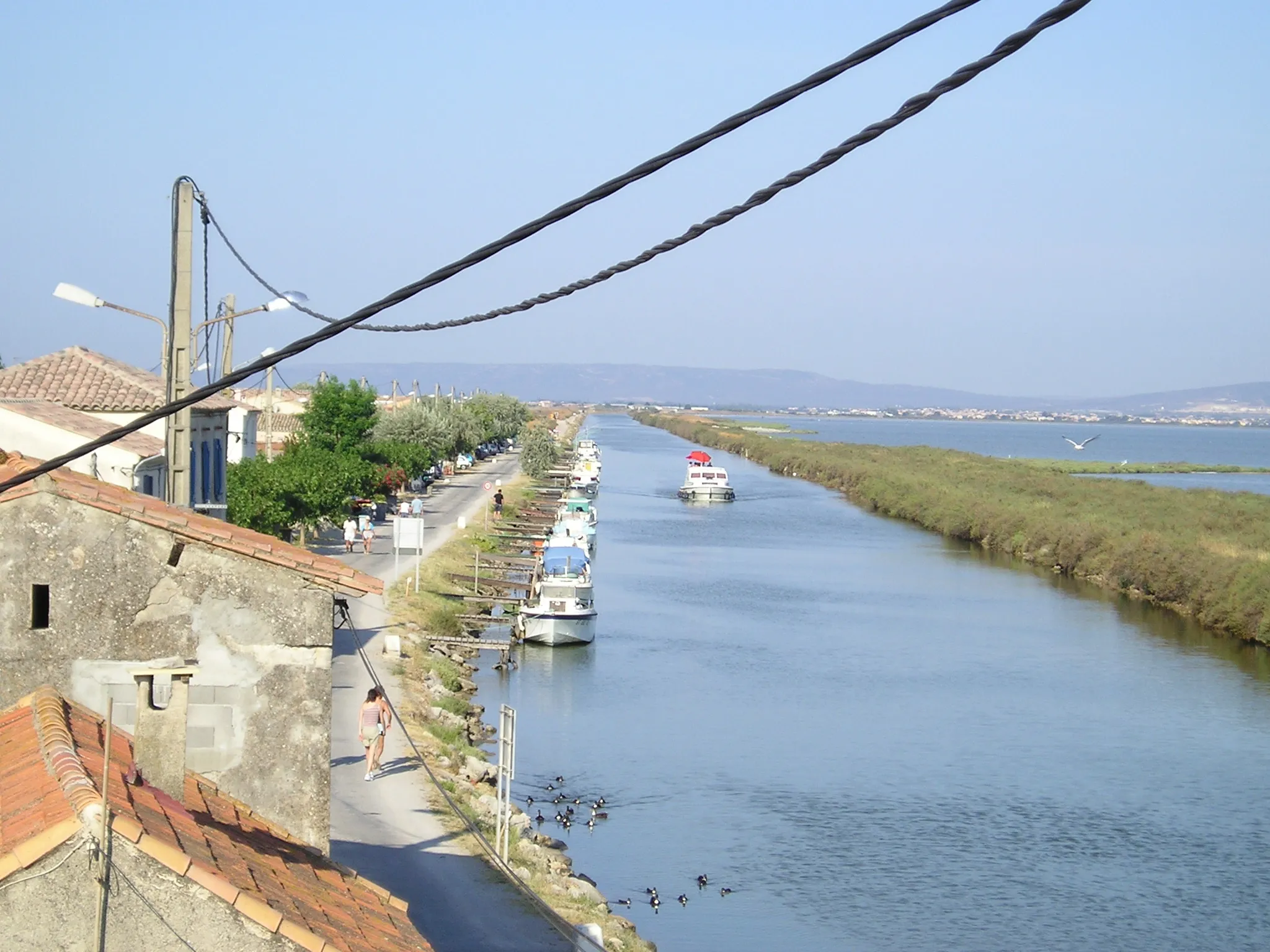 Photo showing: The Rhône to Sète canal, at the Cabanes de Carnon (left) in Palavas-les-Flots. On the right (north-west), the Pérols or Méjean pond ; then far away, Villeneuve-lès-Maguelone. The relief on the background is the Gardiole.