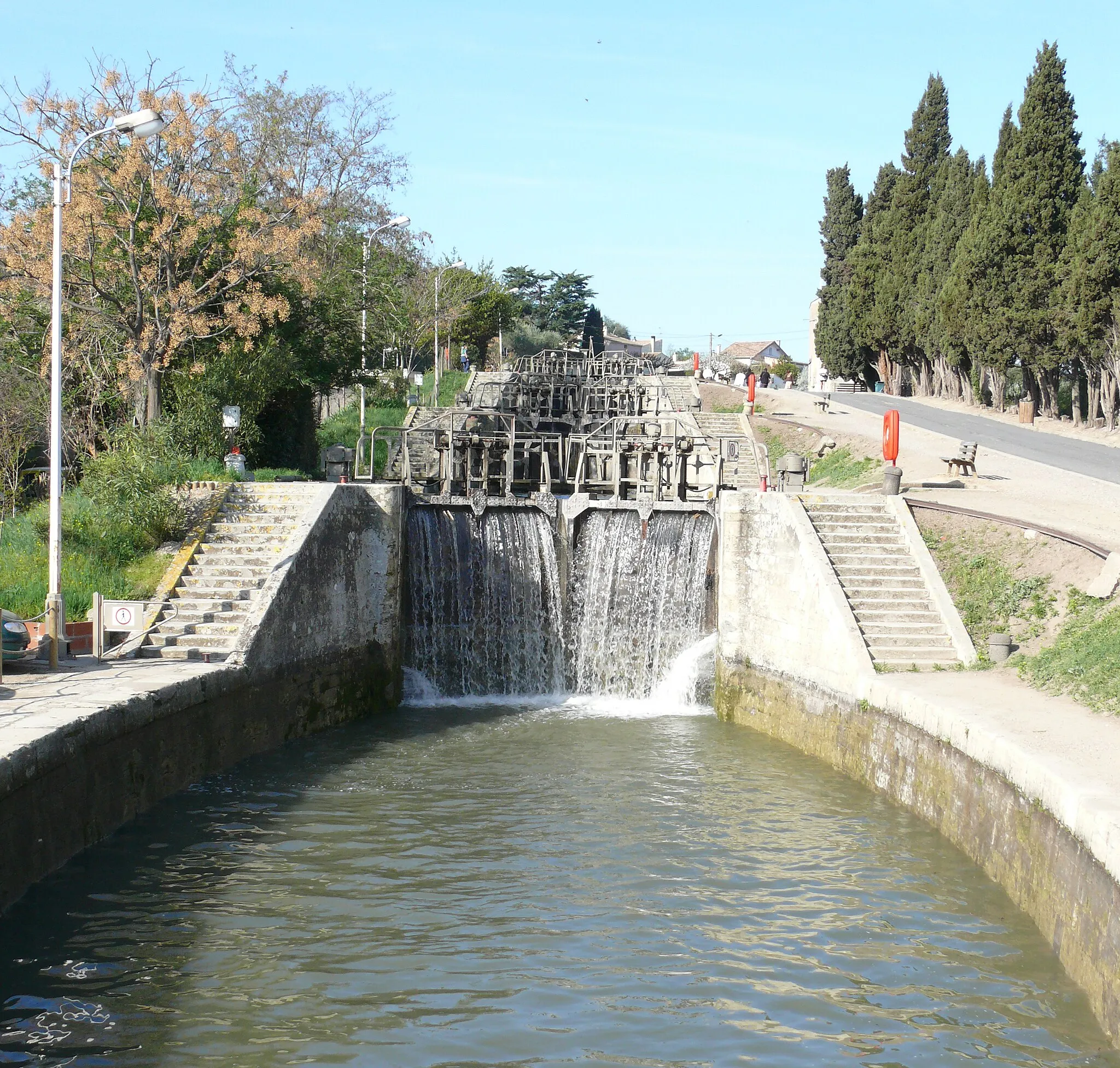 Photo showing: Fonserannes Lock (French: écluse de Fonserannes, les neuf écluses) is a staircase lock on the Canal du Midi near Béziers. 
It consists of eight ovoid lock chambers (characteristic of the Canal du Midi) and nine gates, which allow boats to be raised a height of 21.5 m, in a distance of 300 m.