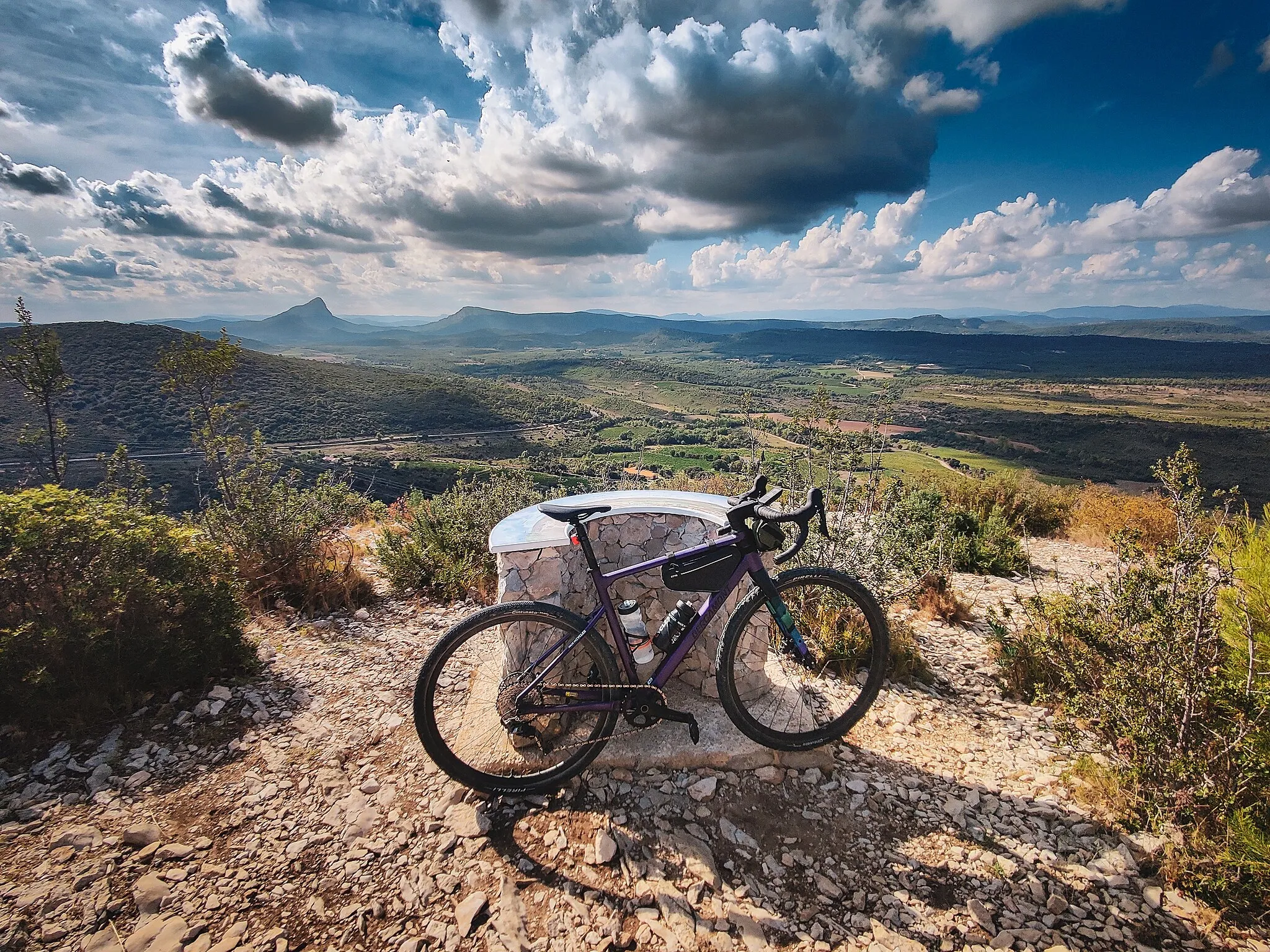 Photo showing: A Bergamont Grandurance gravel bike at the top of the Puech des Mourgues, France, offering a panoramic view over a chain of puechs and Pic Saint Loup.