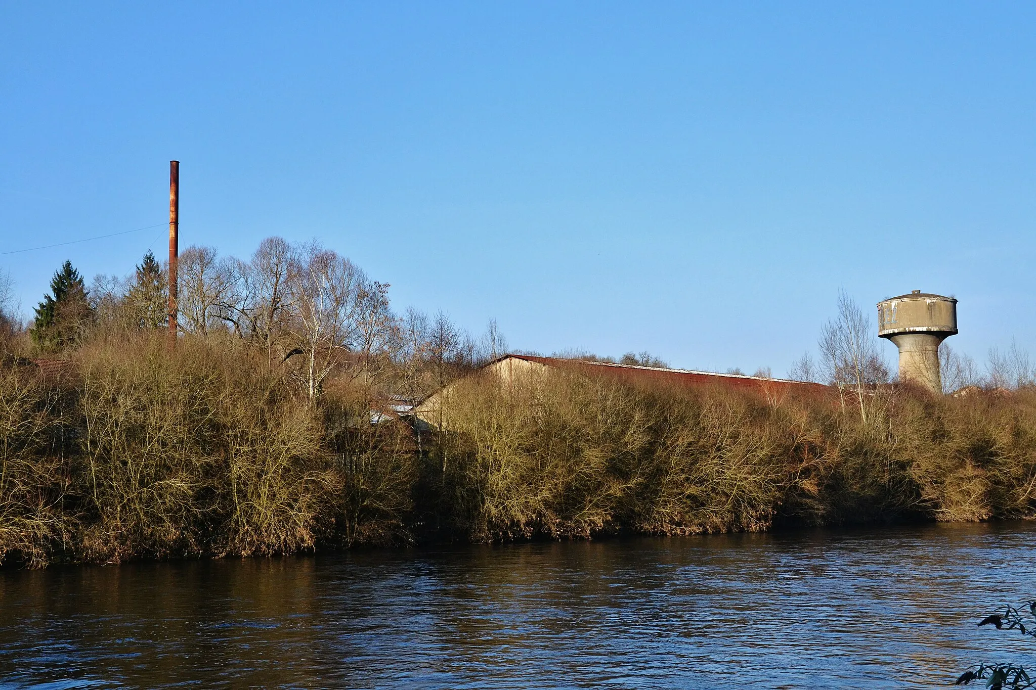 Photo showing: Cheminée, bâtiments et château d'eau de l'ancienne usine de caoutchouc Wattelez, au Palais-sur-Vienne (Haute-Vienne, France).