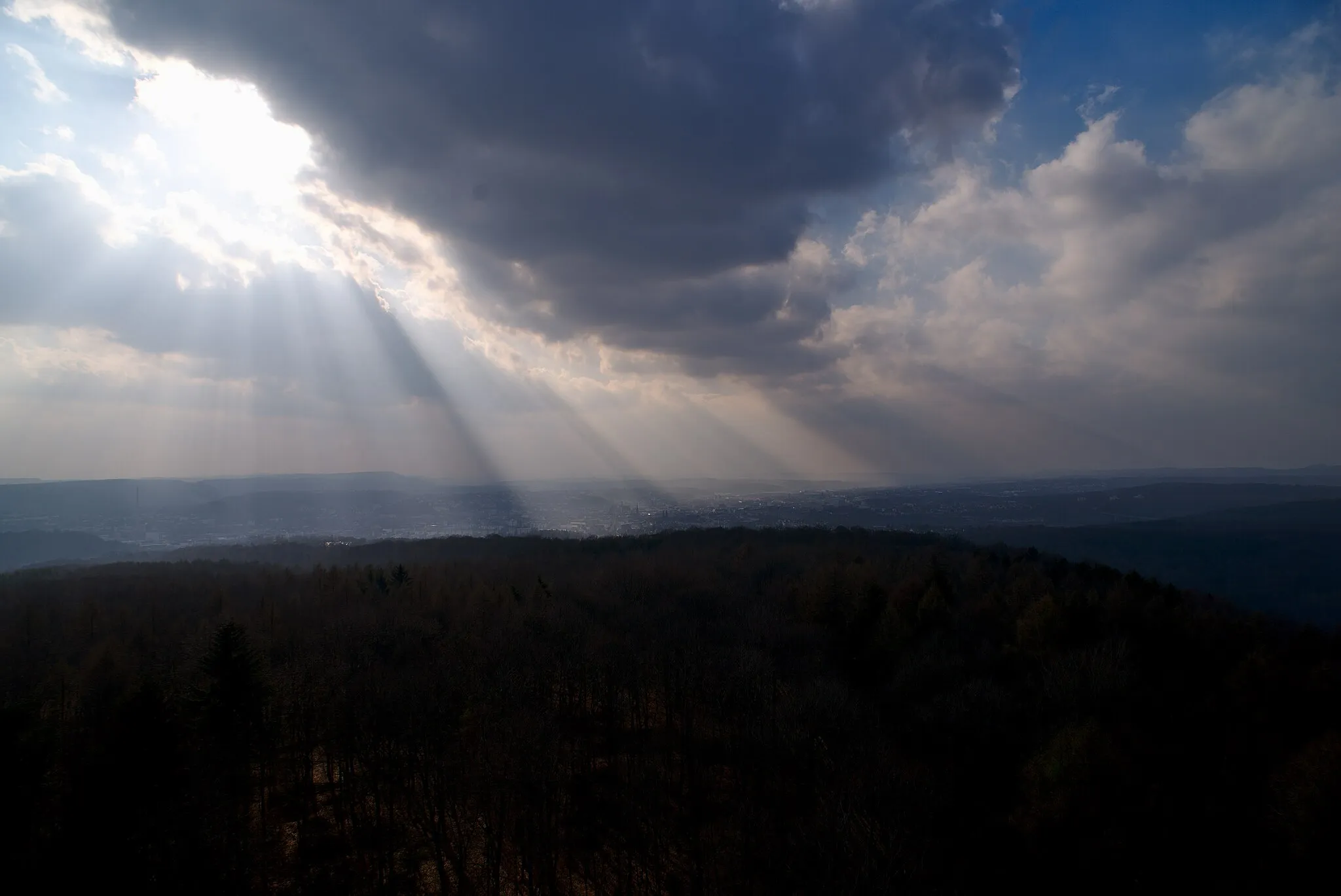 Photo showing: Aussicht von dem Schwarzenbergturm nach Norden auf Dudweiler. Die Sonne wird auf dem Bild größtenteils von den Wolken verdeckt, die jedoch vorbeiziehen. Die ersten Sonnenstrahlen brechen dabei schon durch die Wolken.