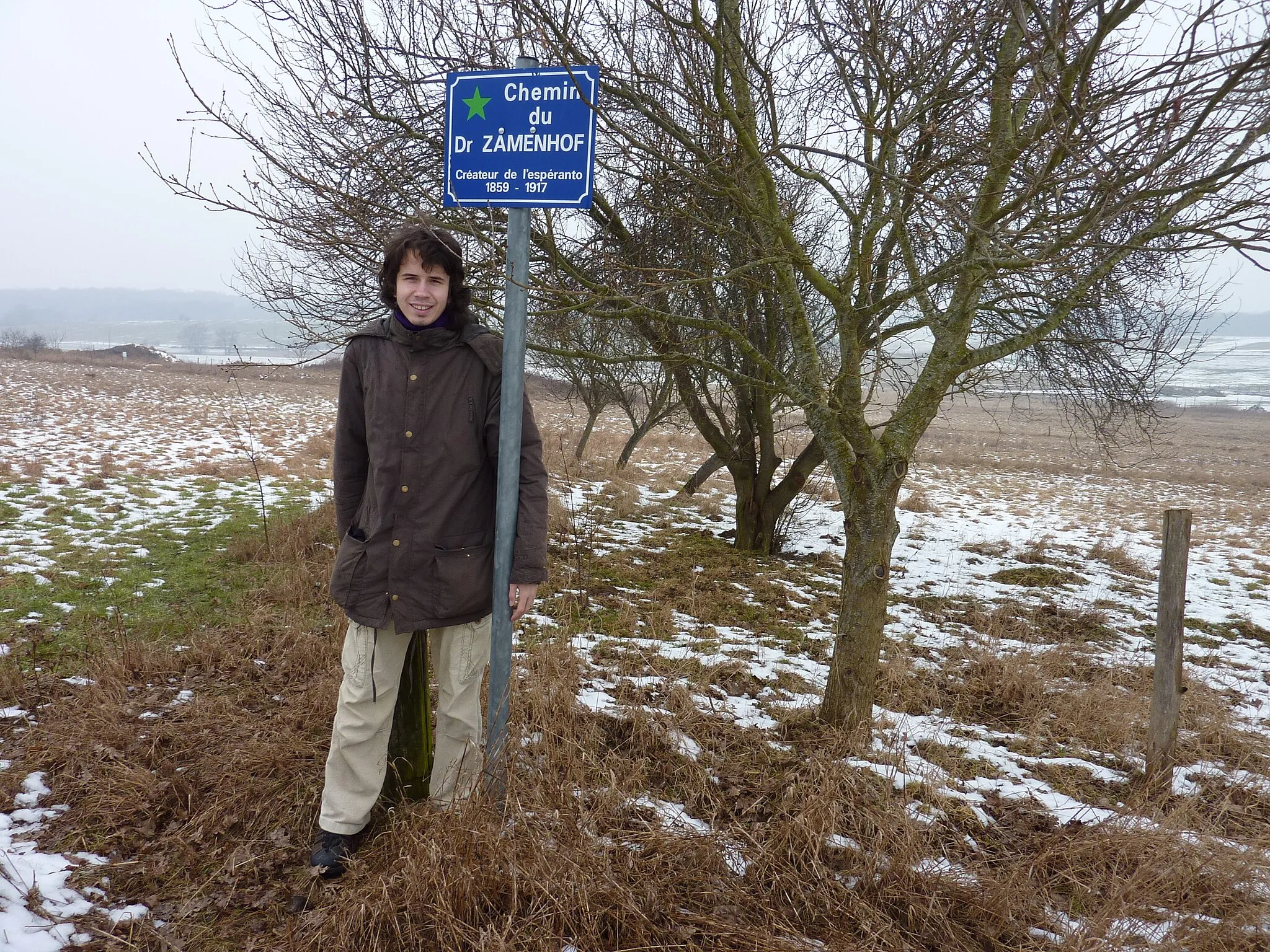 Photo showing: Vojo de D-ro Zamenhof ("Chemin du Dr Zamenhof") inaŭgurita en 2001 en la komunumo Champenoux apud Nancio en Francio – Marek Blahuš, ĉeĥa gasto de ĝia iniciatinto kaj loka esperantisto Roland Genot, apud la strattabulo