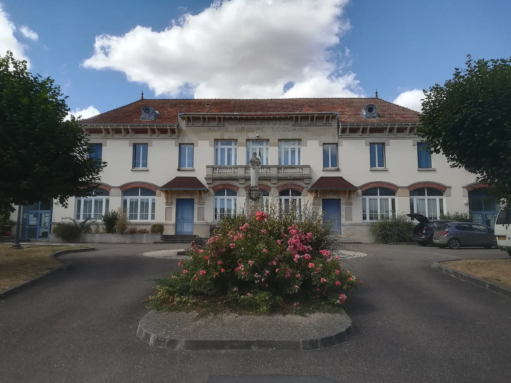 Photo showing: L'ancienne mairie de Consenvoye, qui accueille un groupe scolaire ; devant, le monument aux morts et un parterre fleuri.