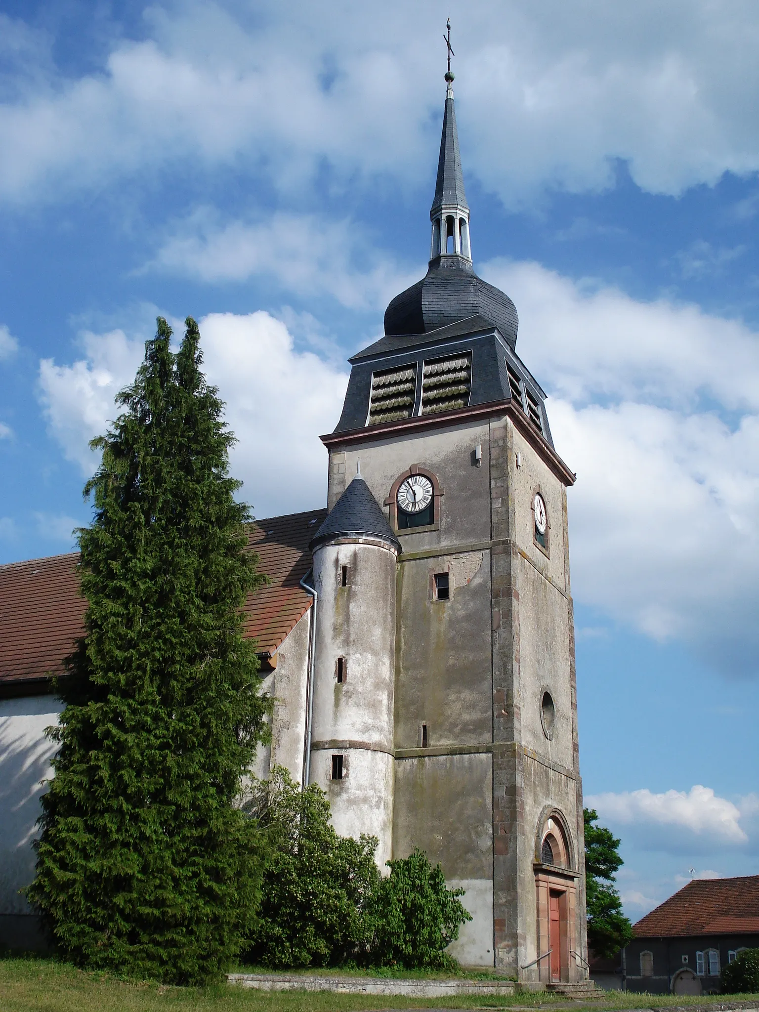 Photo showing: Inaugurée en 1733, l’église comporte une nef de style grange mais se remarque surtout par son clocher à bulbe et à tourelle dû à l’architecte Philibert originaire de Suisse dont l’influence se retrouve même si le clocher actuel a été reconstruit après la Seconde Guerre mondiale.