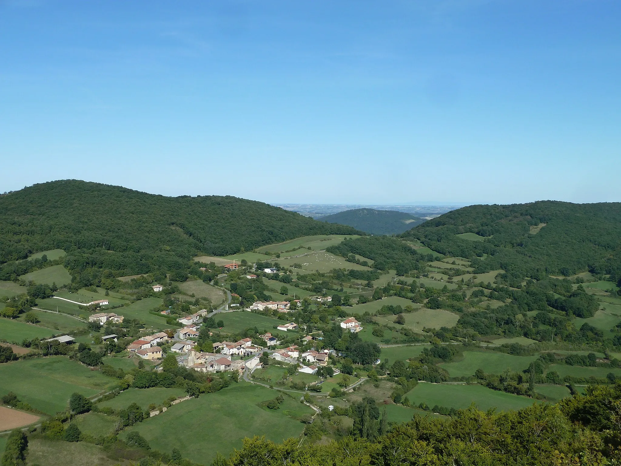 Photo showing: Vue vers l'est-nord-est sur Ausseing depuis le sommet de la Roque. En bas de la photo, faisant une boucle et partant vers la droite, le "chemin ancien" qui rejoint la route de Belbèze à environ 250 m du bord droit de la photo ; le ruisseau de Lariou prend source dans cette boucle de la route. Derrière cette route, l'actuelle route de Belbèze qui part vers la droite en longeant le pied du coteau ; puis la petite route qui ne dessert que le hameau de Pentecôte, part dans la même direction mais grimpe sur le coteau. S'éloignant vers l'arrière en direction de la passe, la route de Mauran (D83).
La hauteur à droite (alt. 591 m) est le début de l'Hajaou. A gauche, le sommet de la tour d'Ausseing (alt. 613 m). Entre les deux, la passe mène sur le versant opposé au ruisseau de Saint-Antoine, affluent du ruisseau de Tournis lui-même affluent de la Garonne au nord. En arrière-plan dans l'axe de la passe, on aperçoit la hauteur du mont Saboth qui porte le château de Saint-Michel (alt. 510 m).