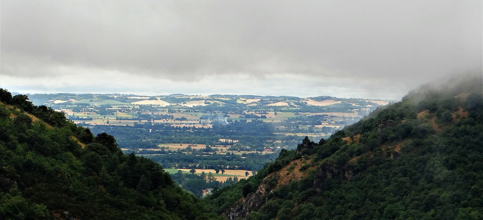 Photo showing: Durfort (Tarn) - Vallée du Sor et plaine de Sorèze vues vers le nord-ouest depuis la route de Pont-Crouzet vers Les Cammazes. Revel est dans la plaine derrière le pan de montagne à gauche. A l'horizon, les hauteurs sur lesquelles est implanté Puylaurens.