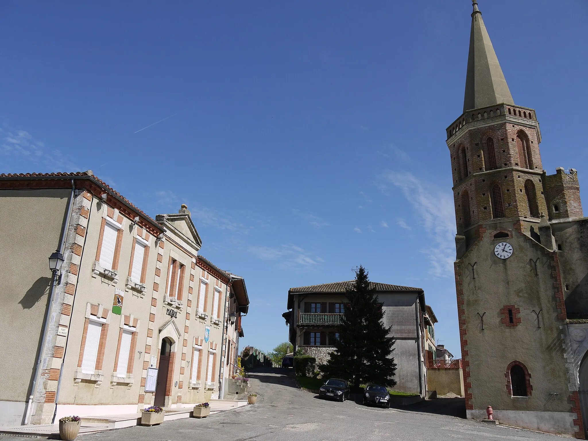 Photo showing: La Place de la Mairie, avec la mairie à gauche et l'église à droite, à Aubiet