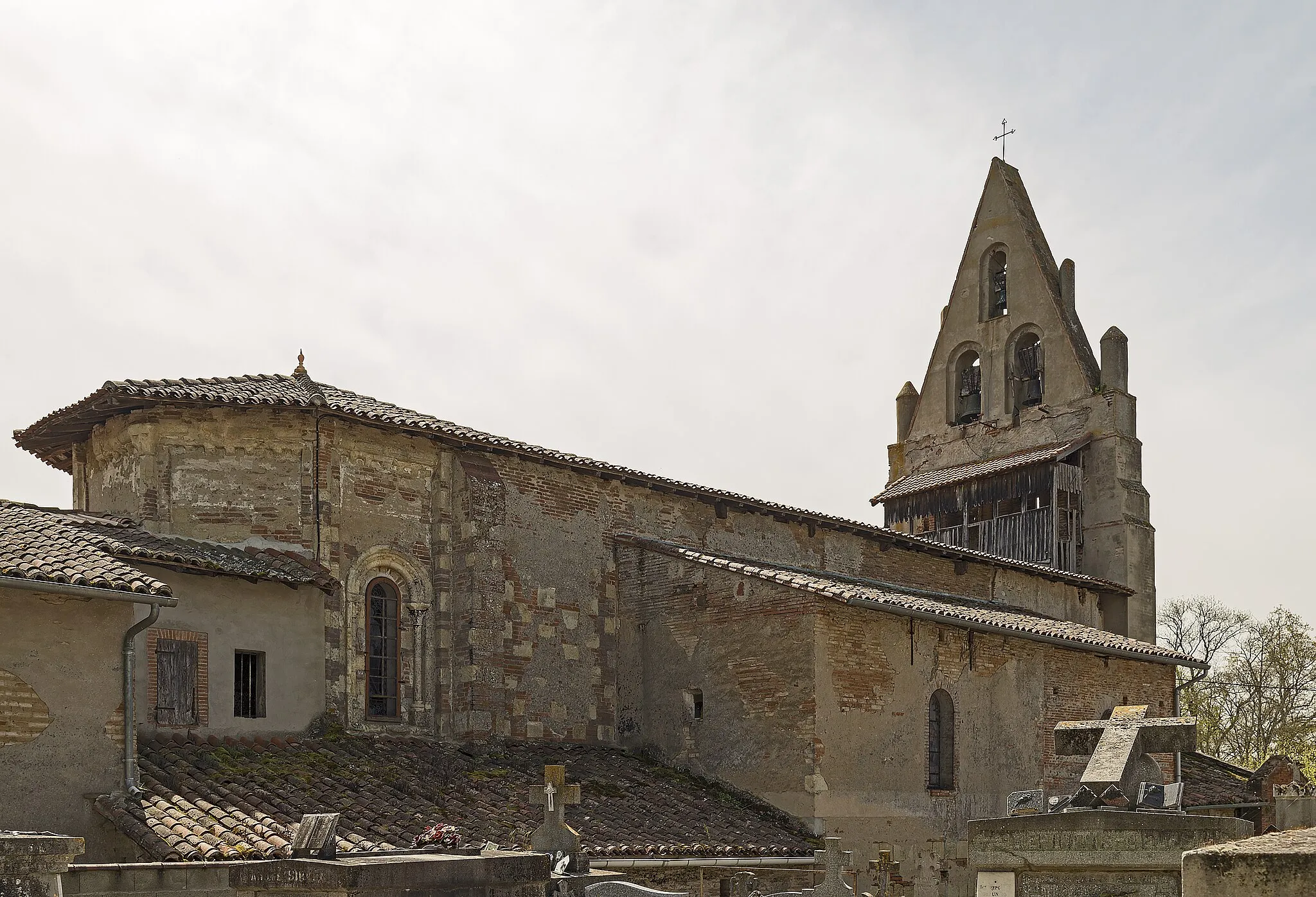 Photo showing: St. Peter's Church of Dieupentale, Tarn-et-Garonne, France. The Romanesque apse of the twelfth is masked in part by the buildings of the rectory. Note the foothills columns and cornice corbels under the roof. The nave and the bell gable date from the seventeenth century.