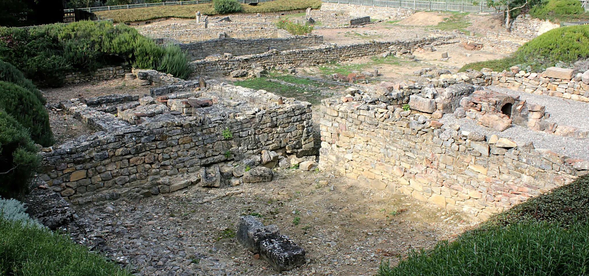 Photo showing: General sight of the site of Graufesenque, the very large oven on the right, the hypocauste (underfloor heating) on the left. The foreground was a site of storage of clay for the workshops of potters. At the background can be seen the habitats of potters, converted into workshops, where many slaves were living. Nearly 200 accounts of owners potters were found.