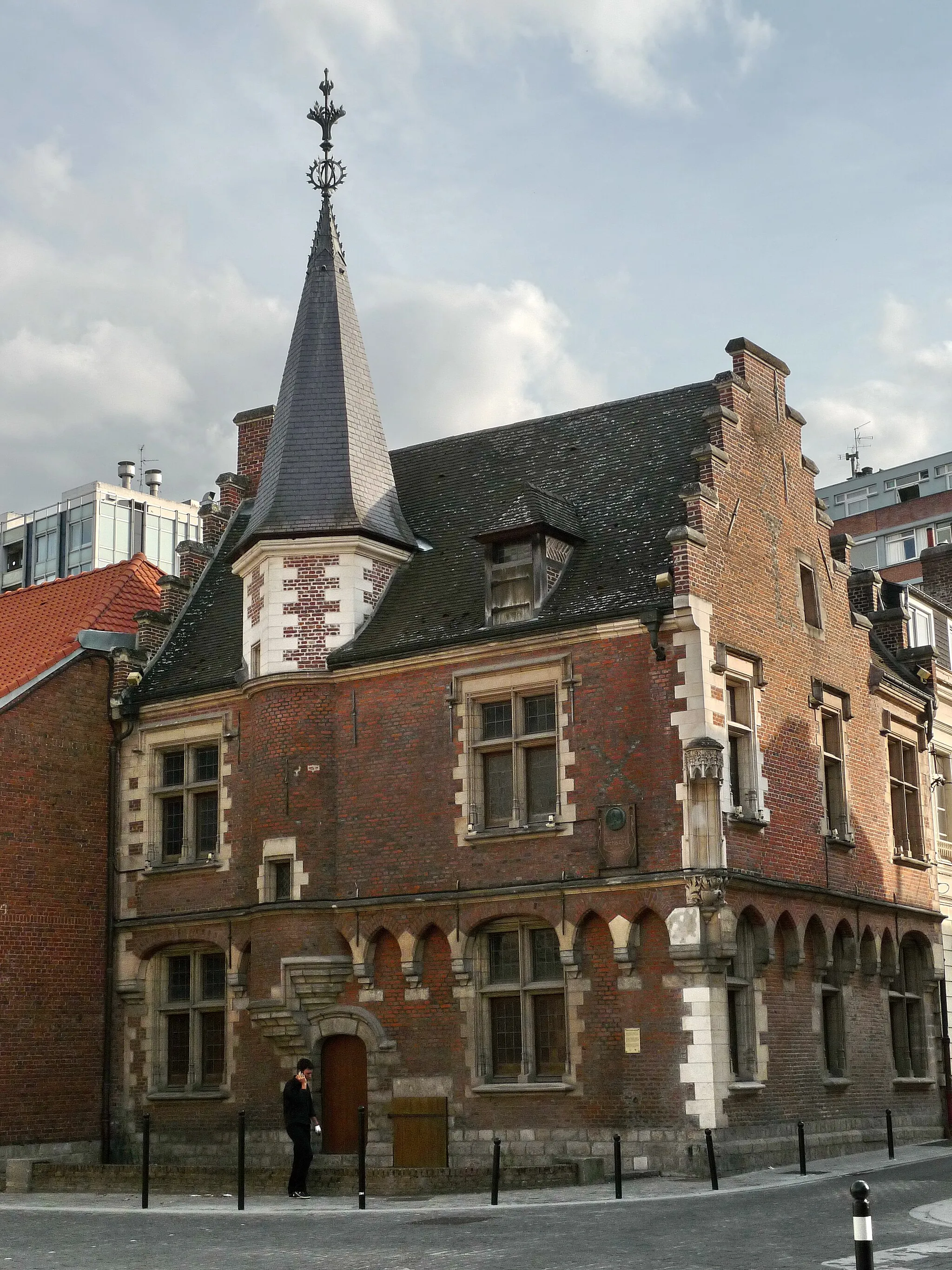 Photo showing: Valenciennes, "Maison du Prévôt" : building dating from the end of XIV th century, covered the following century with a fine course of brick and stone. Crow-stepped gable,mullioned windows,small arcades, carved niche, turret surmounted with a pinnacle.(rebuilt in the 1990s)