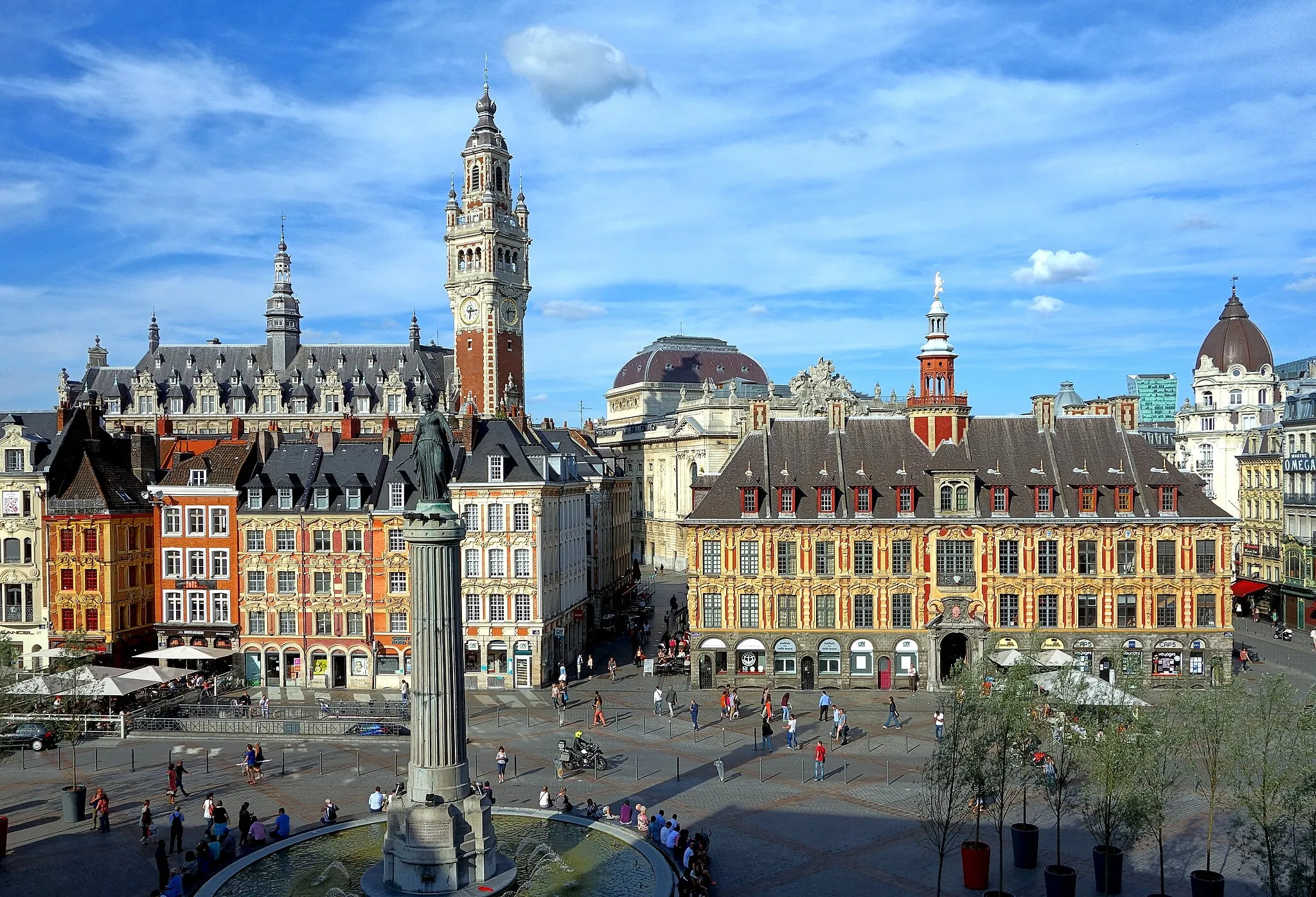 Photo showing: Place du Général de Gaulle, the central square of in Lille, northeastern France. Behind the Column of the Goddess is the bell tower of the Chamber of Commerce. The large building to the right (on the square) is the Vieille Bourse (Old Stock Market).