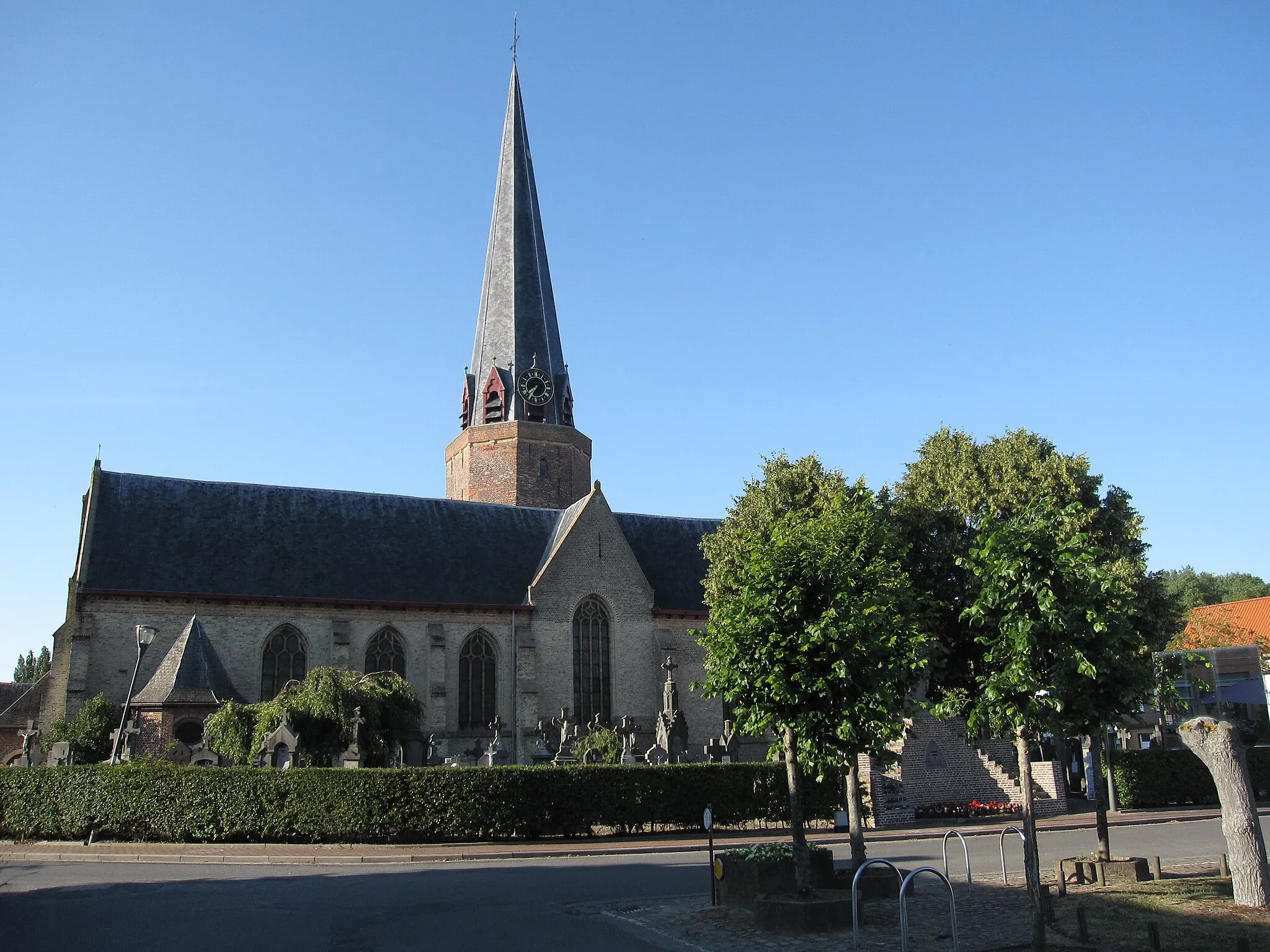 Photo showing: The Watou church and cemetery is located next to Watouplein, the square in the center of the village. During World War 1, called the Great War in Belgium, Watou and its surroundings was a quiet resting area behind the lines. No armed conflicts took place here, so the church only saw a few war funerals between April 1915 (the second battle of Ypres) and November 1918 (when the war ended).