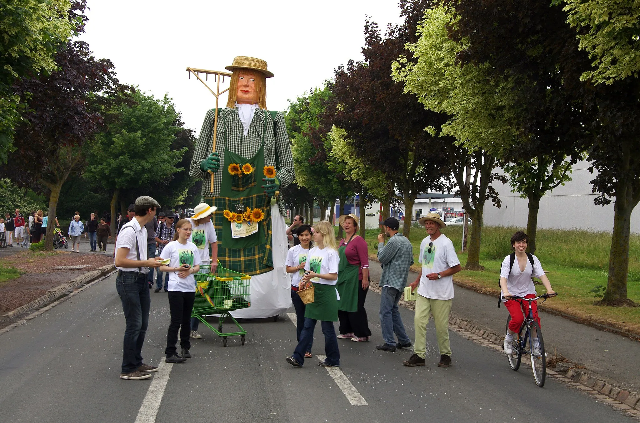 Photo showing: Sainte-Catherine-lès-Arras (Pas-de-Calais, France) - Animation festive avec défilé de géants, un dimanche de juin.
Le départ a eu lieu route de Béthune, depuis le parking du supermarché "Intermarché". Le géant Albert la main verte, suivi d'un groupe de musiciens, ferme la marche.
.