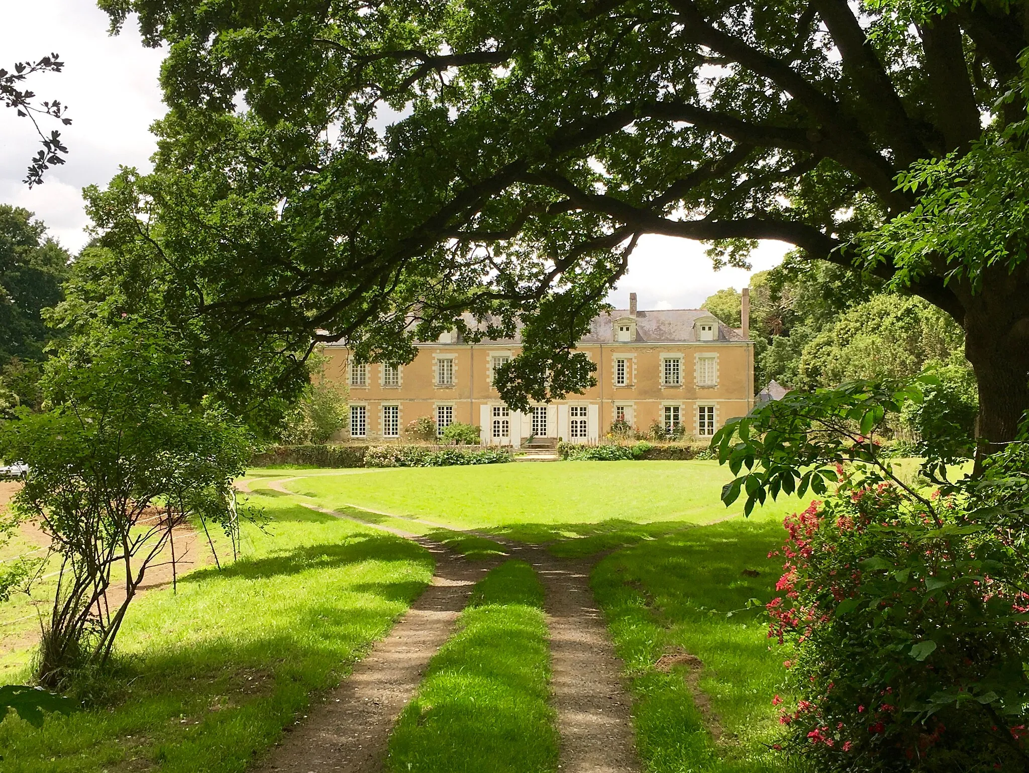 Photo showing: Façade principale du Château de Launay masquée par les arbres.