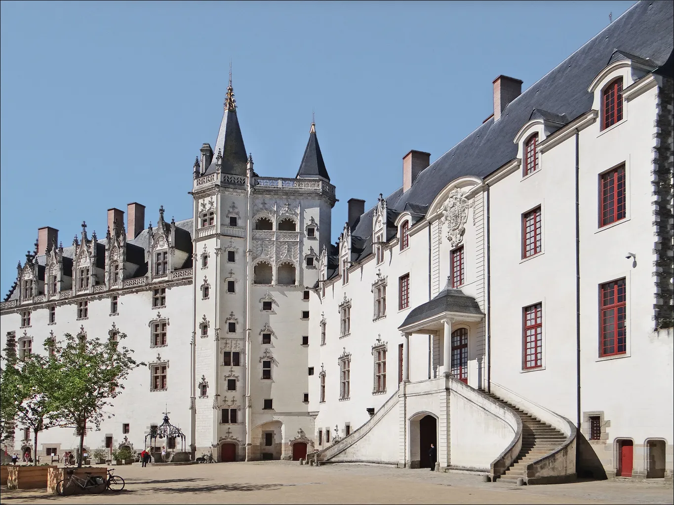 Photo showing: Le Grand Logis (à gauche) et le Grand Gouvernement (à droite). Au centre, la tour de la Couronne d'Or.
Commencée par François II, la tour de la Couronne d'or est achevée par Anne de Bretagne qui, après son mariage avec Louis XII en 1499, entreprend d'embellir le Château. Symbole de l'autorité ducale et royale, deux flèches surmontent la tour dominant l'horizontale des courtines.
Jusqu'à la fixation de la cour à Versailles sous Louis XIV en 1683, la monarchie française a conservé une tradition de nomadisme. Lorsque le Roi passait à Nantes, le château lui servait de logement.
Site du Château-musée

www.chateau-nantes.fr/fr/chateau_musee/un_monument_un_mus...