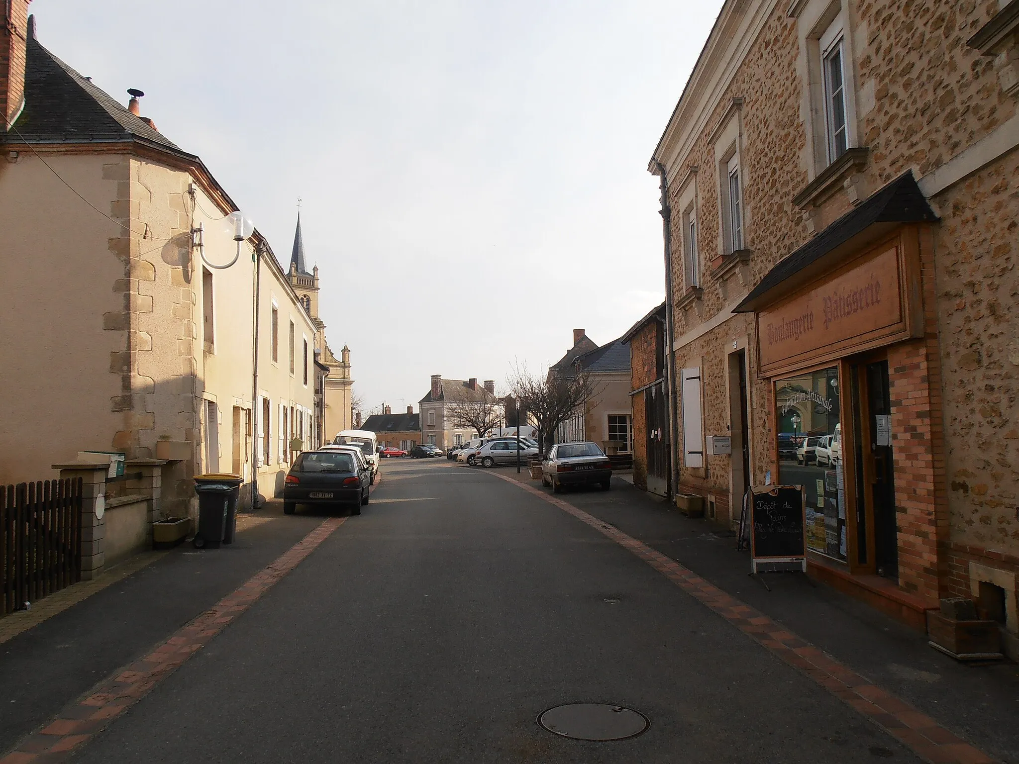 Photo showing: Les Rairies (Maine-et-Loire, France) : la rue principale du village où se situent les commerces, l'église et la mairie.