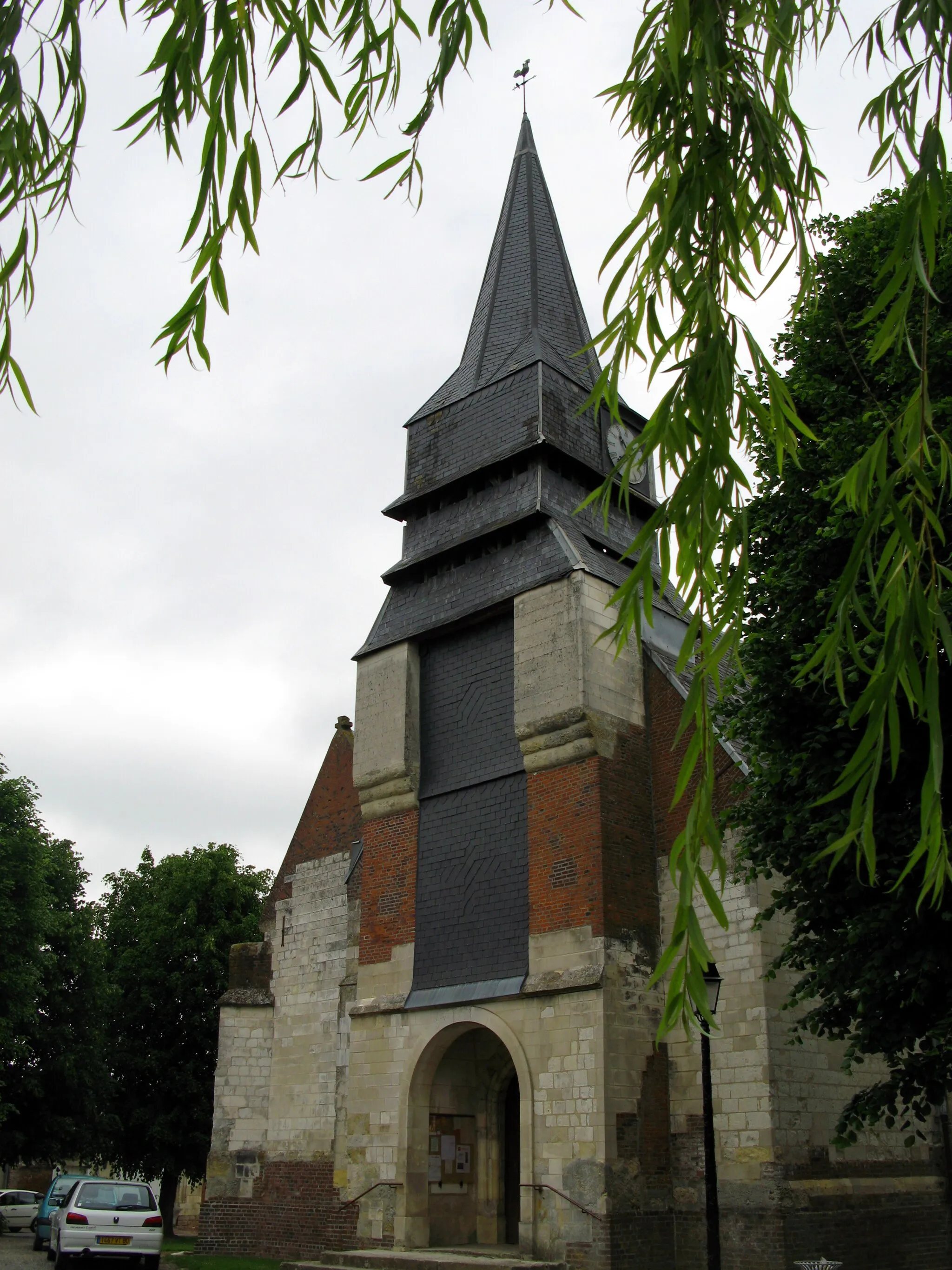 Photo showing: Sains-en-Amiénois (Somme, France) - Eglise.
On remarque :

la position de l'horloge, non centrée sur le côté du clocher.
le léger surplomb des pierres supérieures de la face du clocher.