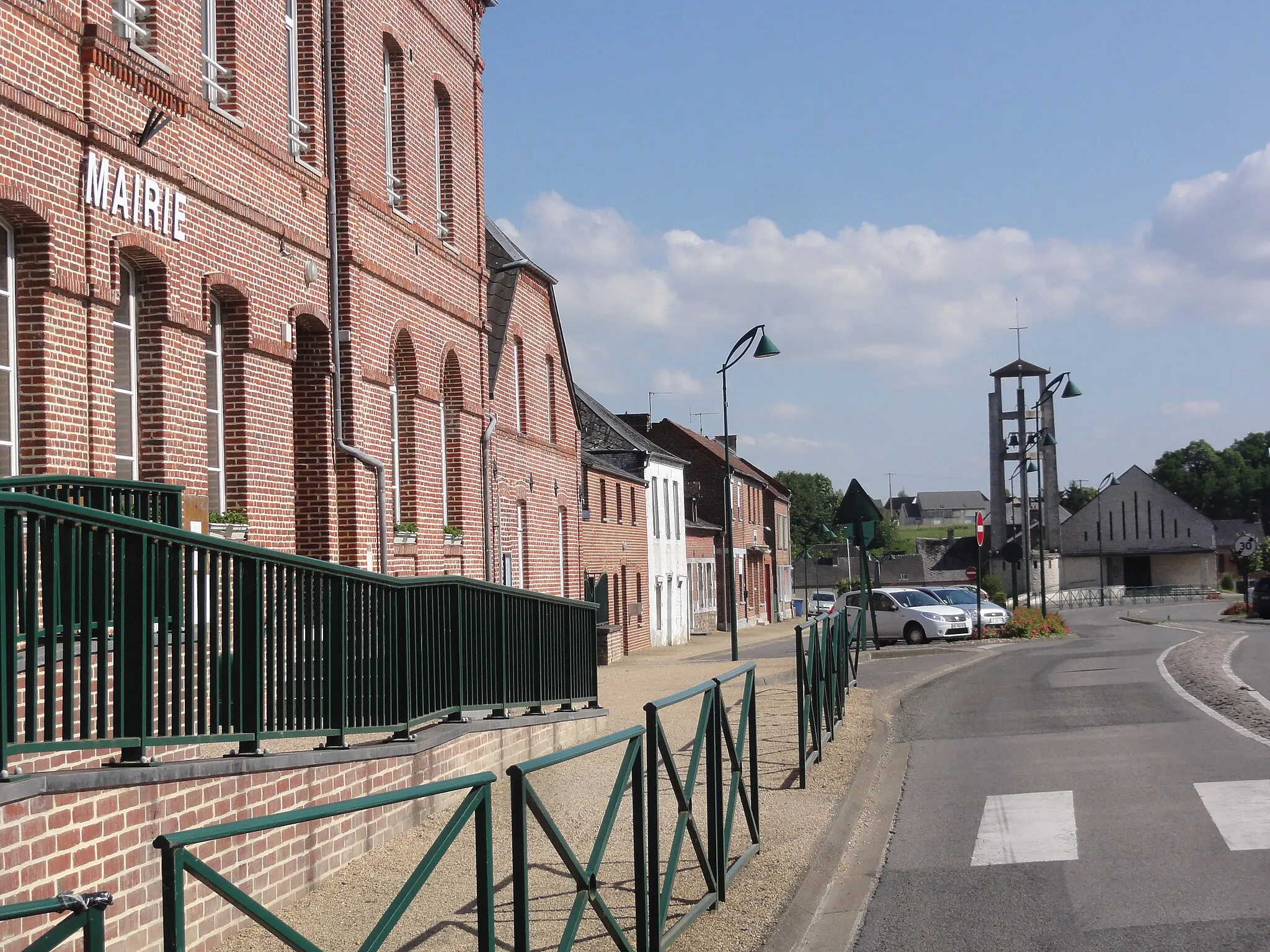 Photo showing: Mondrepuis (Aisne) rue de l'église, à gauche la mairie, au fond l'église