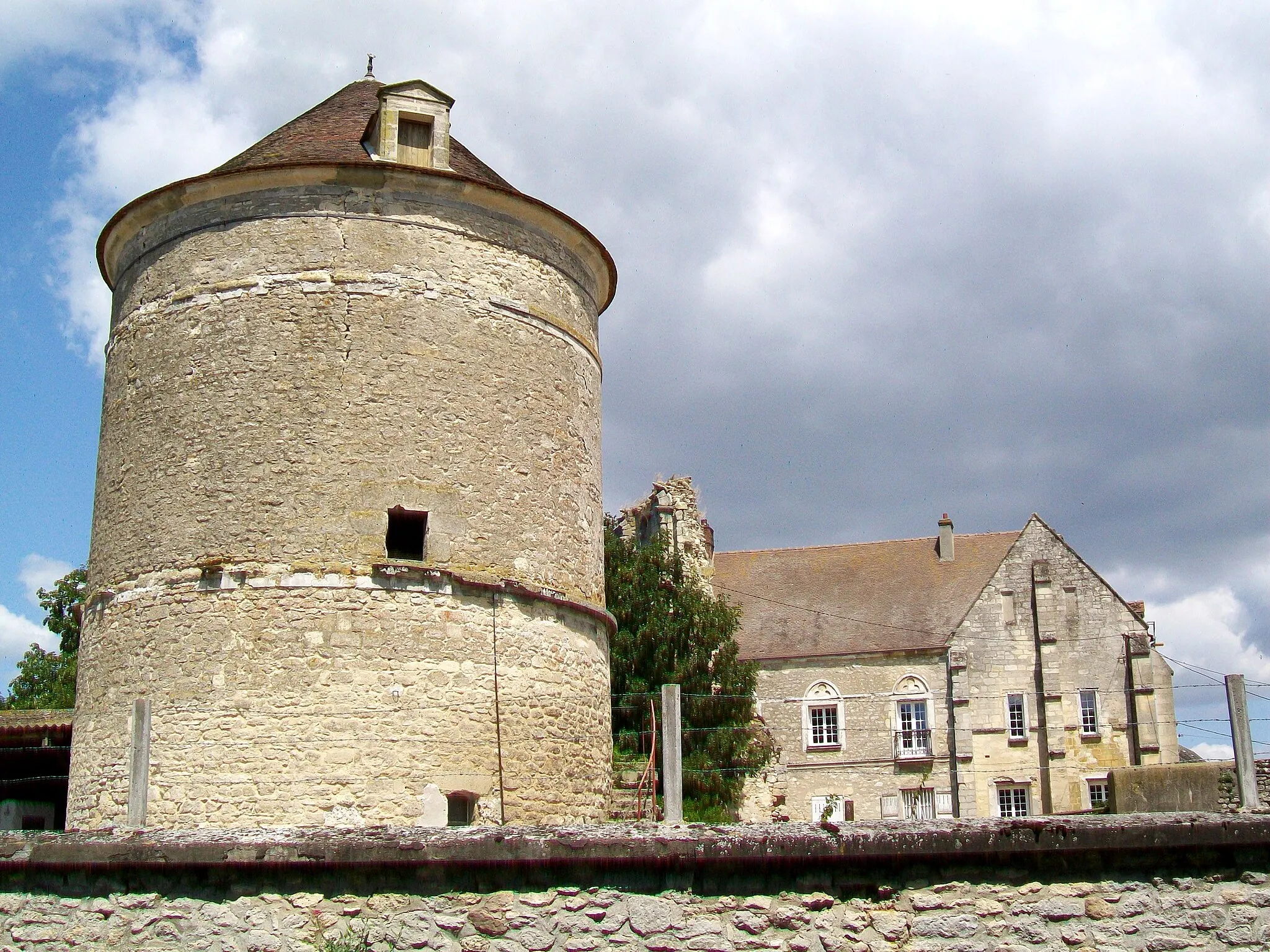 Photo showing: Le colombier de la ferme du Prieuré, vestige du clocher de la chapelle du XIIe siècle et façade sud de l'ancien prieuré Sainte-Geneviève du XIVe siècle.