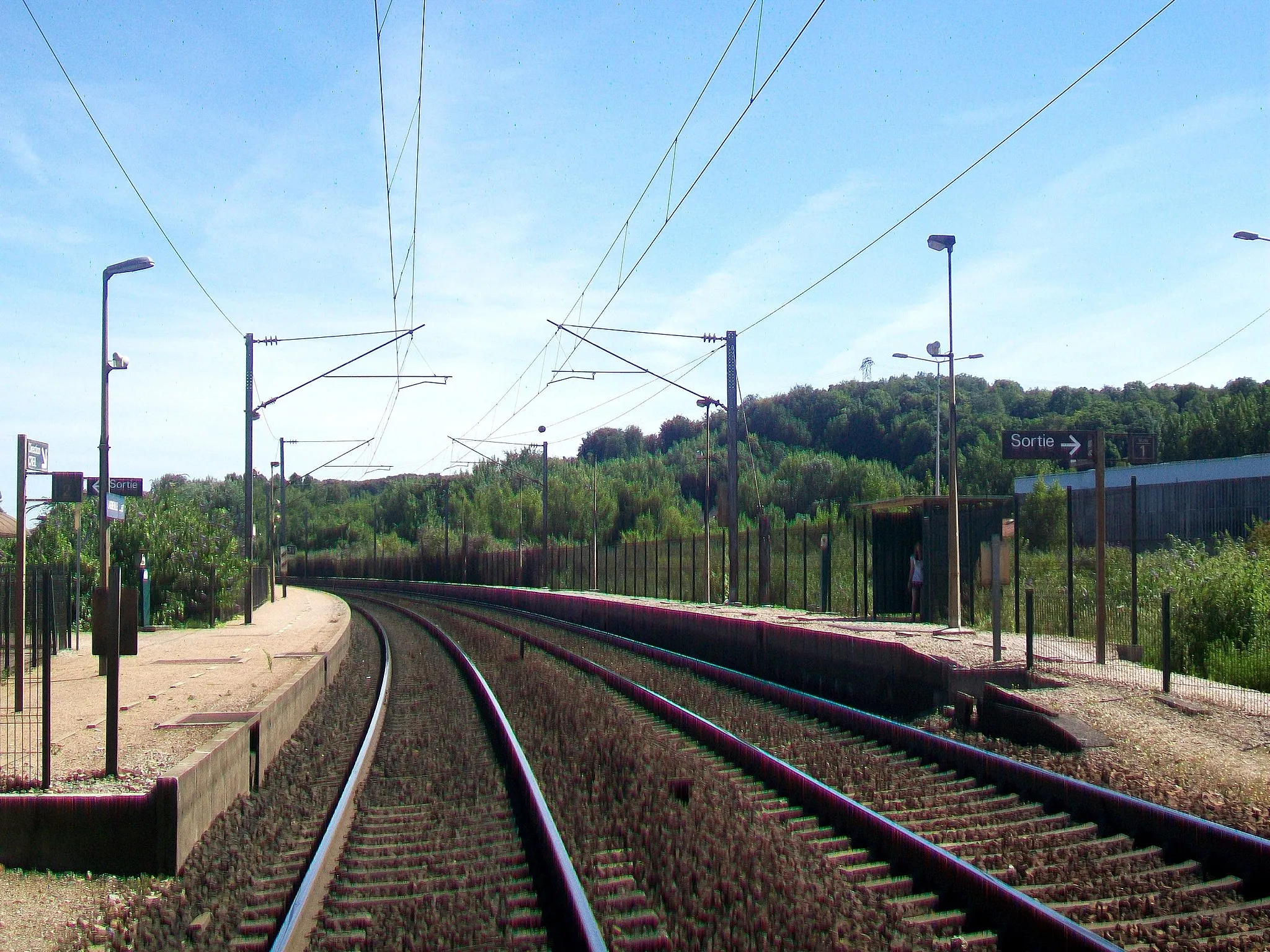 Photo showing: L'arrêt SNCF depuis le passage à niveau, vue en direction de Creil et Paris. A droite, le quai de la voie n° 1 en direction d'Amiens, côté village ; à gauche, le quai de la voie n° 2 en direction de Paris. Ce quai est accessible par le passage à niveau.