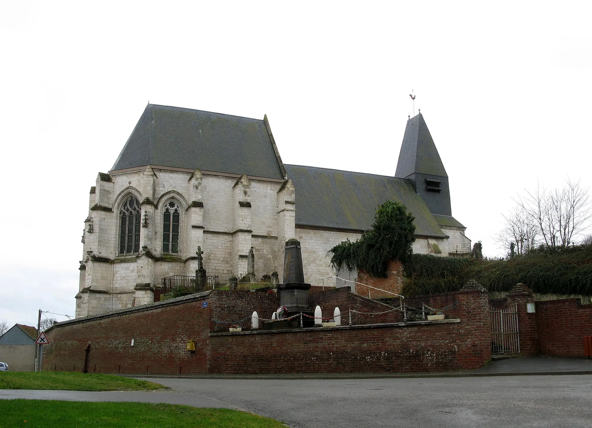 Photo showing: Riencourt (Somme, France) -
L'église, vue alors que la petite pluie d'automne semble juste s'arrêter.

En léger contrebas mais surplombant la rue, le monument aux morts entouré de 4 obus.