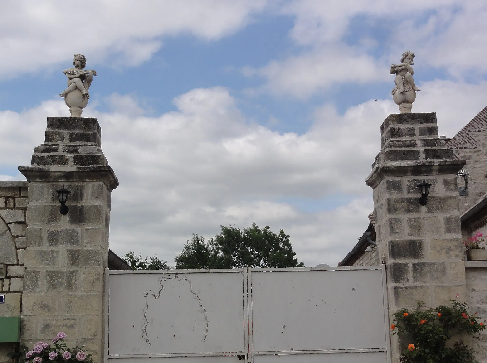 Photo showing: Mâchecourt (Aisne) statuettes sur porte de ferme