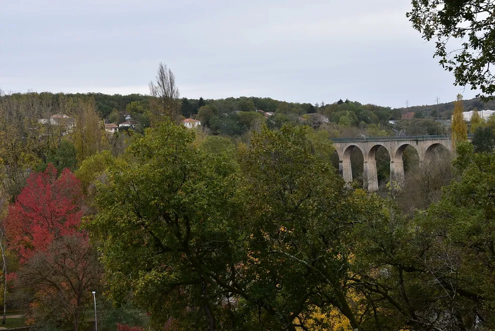 Photo showing: Viaduc de St-Benoit (86).
Mis en service en 1896 pour le passage du tram à vapeur Poitiers-St Martin l'Ars, liaison d'une cinquantaine de km à voie métrique, comme souvent à l'époque pour ce type d'infrastructure relevant des réseaux départementaux.
C'est un ouvrage mixte arches de pierre + travée métallique franchissant, sur près de 330 m, vallée du Clain et ligne classique Paris-Bordeaux.
Les derniers convois l'empruntent en 1934, mettant ainsi un terme à une aventure de moins d'un demi-siècle, ce qui est bref.

Les voyageurs qu'on y croise aujourd'hui sont piétons et 2 roues.