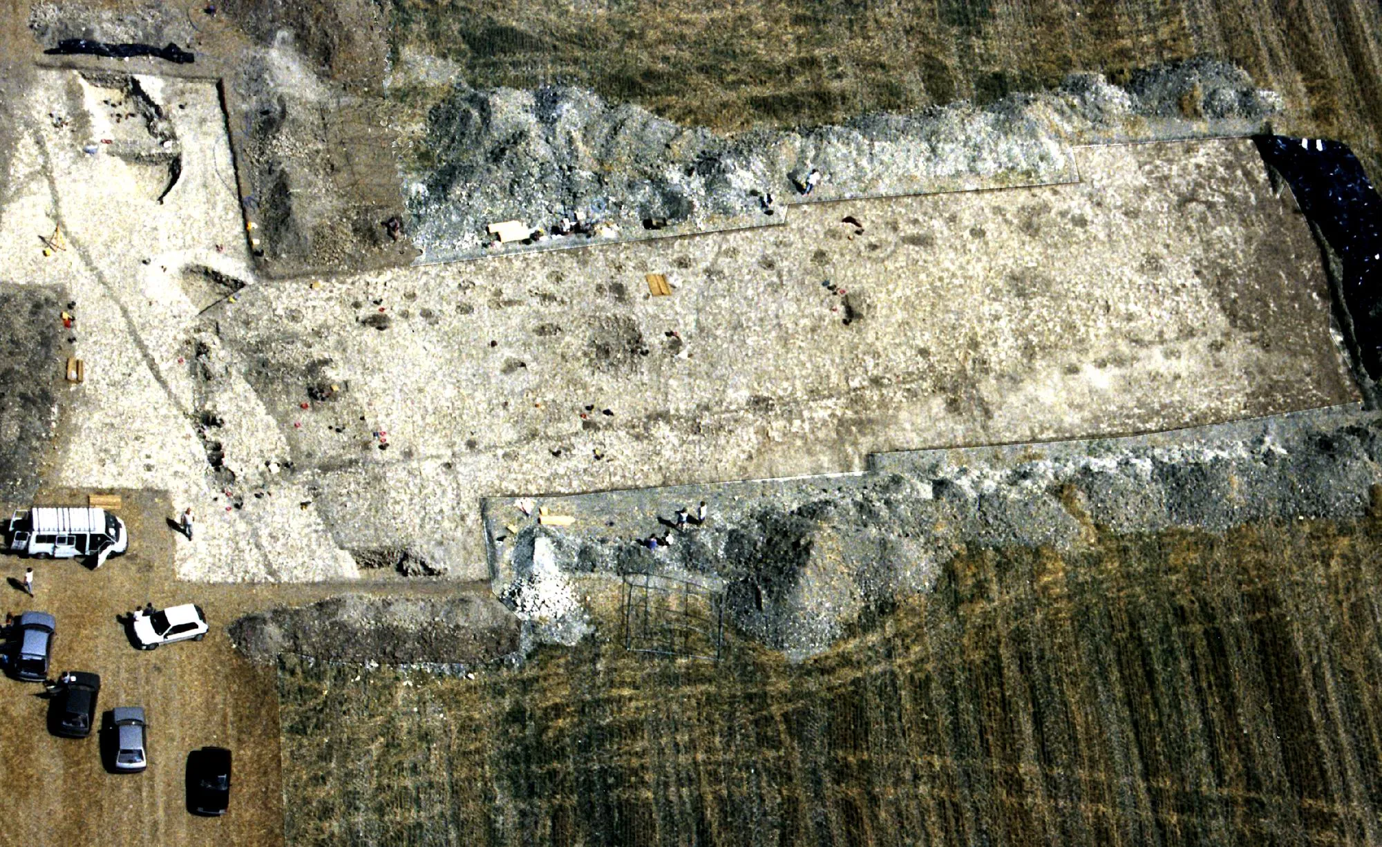 Photo showing: Vue aérienne de la fouille du grand bâtiment rectangulaire (60 x 12m) situé au coeur de l’enceinte à fossé et rempart d’époque artenacienne (Néolithique final) du Camp à Challignac (Charente). Photographie prise lors de la campagne de fouilles 1996-2000, dirigée par Claude Burnez.