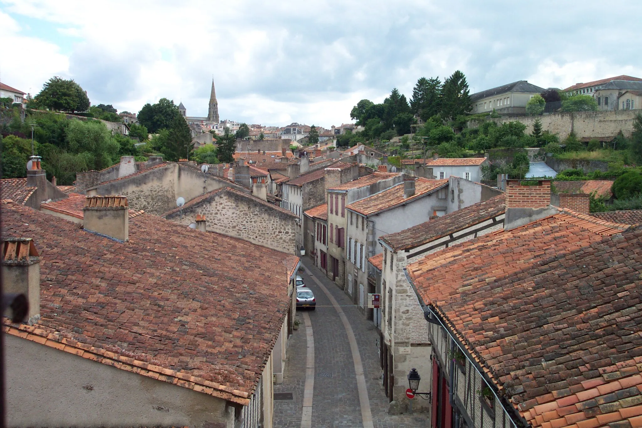 Photo showing: The Rue de la Vau Saint-Jacques in Parthenay, photographed from the upper chamber of the Saint-Jacques Gate, and looking up the hill to the town centre. The eastern wall of the citadel can be seen to the upper right. For more information, see the Wikipedia article Parthenay.
