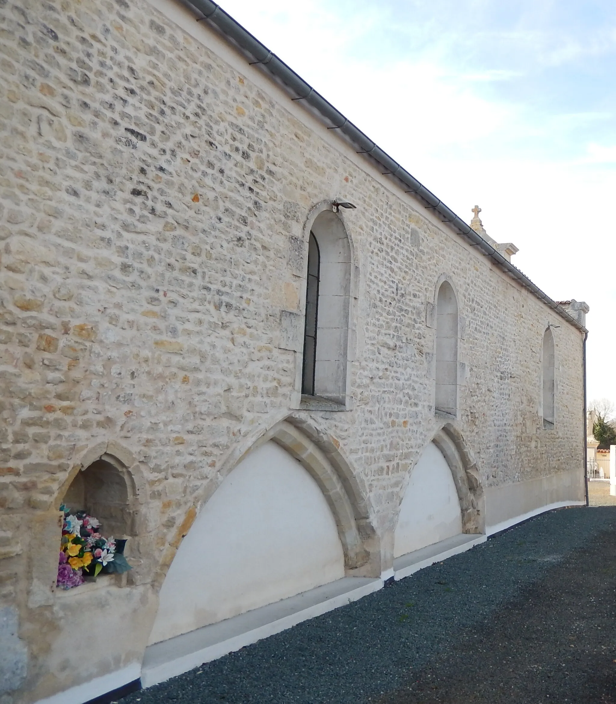 Photo showing: Saint-Ouen-d'Aunis, Charente-Maritime, France. La façade nord-est de l'église du village, montrée sur cette photo, laisse apparaître deux formes en ogive ; ces formes laissent supposer que cette église a eu une structure différente par le passé.