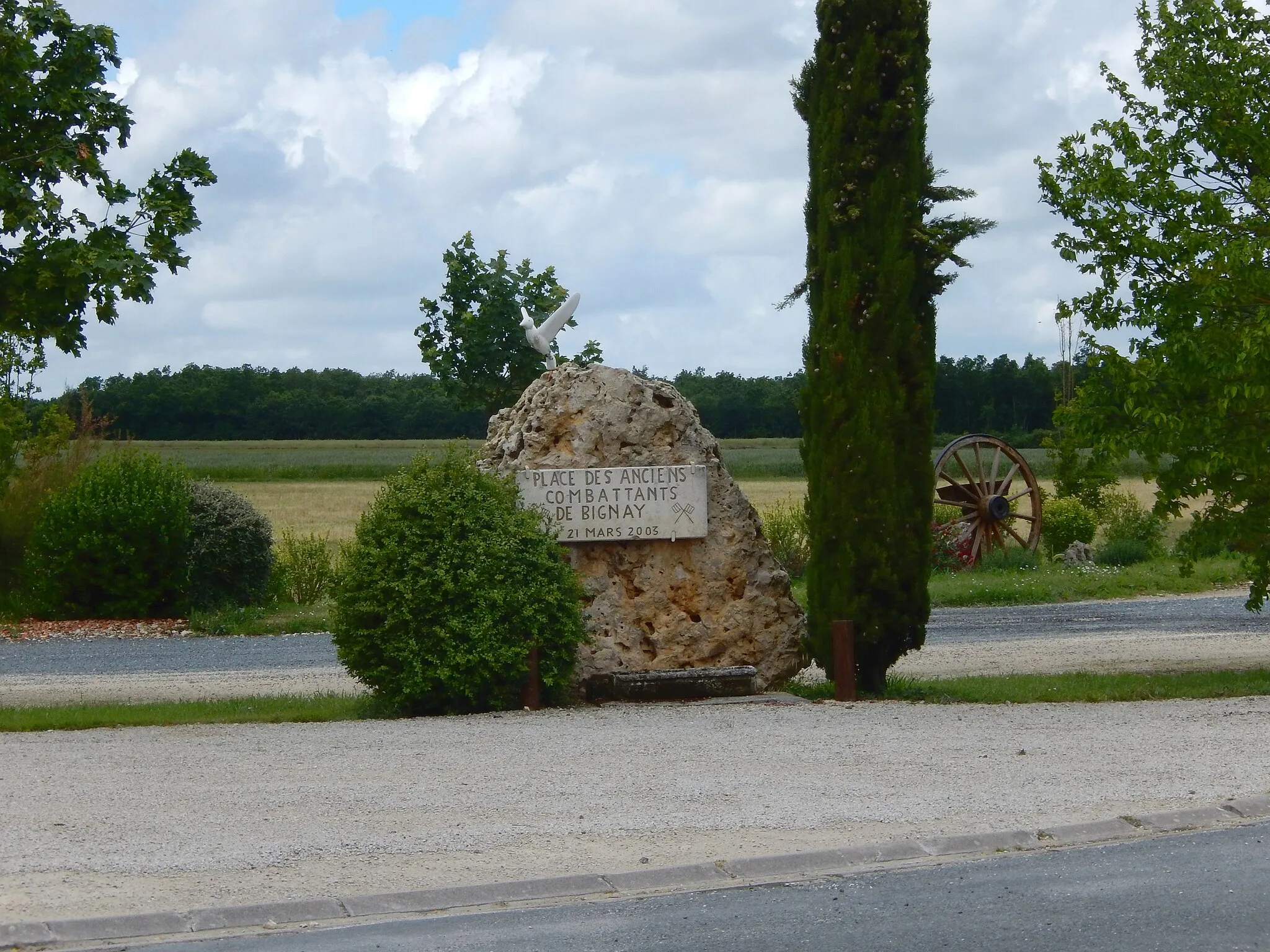 Photo showing: Stone placed on the "Place des Anciens Combattants" (Veterans Square) in Bignay, Charente-Maritime, France. An old wheel can be seen in the background.
