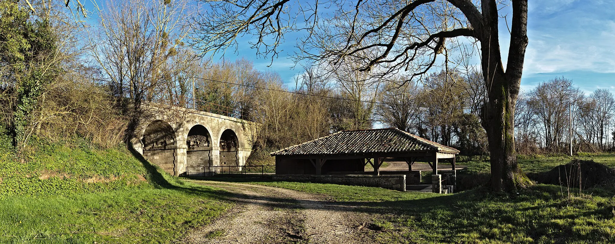 Photo showing: Fontaine de Lusseray et pont ferroviaire (voie désaffectée)
