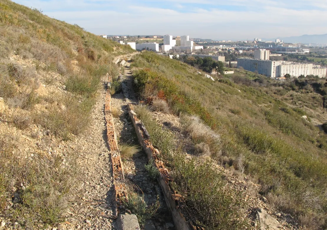 Photo showing: Le canal de l'Estaque à l'approche du vallon de la Pelouque. Vue en direction de l'amont. La détérioration de la canalisation fait apparaître sa construction en briques recouvertes de ciment. Sur la droite la cité de la Bricarde.