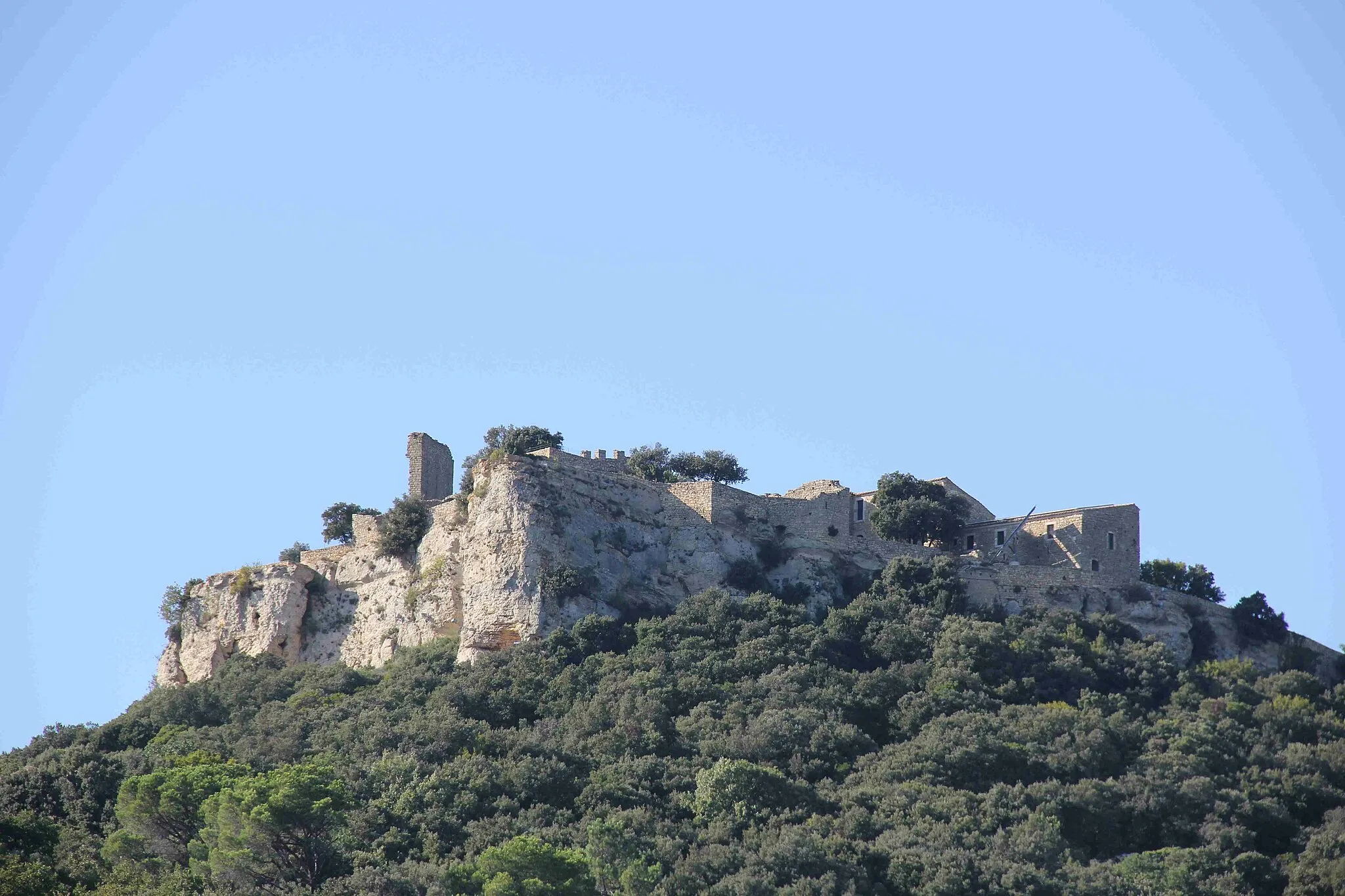 Photo showing: Le site de Gicon, point culminant de la commune de Chusclan, servait selon toute probabilit é, de plate-forme à signaux permettant de communiquer avec les autres points hauts de la région : Sabran, le Camp de César à Laudun, le Castellas de St-Victor-la-Coste, et d'autres. Un fortin domine le chemin qui mène droit au Rhône, accès principal à Gicon, que St-Louis emprunta. L'occupation de Gicon est probablement préhistorique (siège d'une des sept tours à feu Celtes). Gicon domine le passage antique du gué de Carmignan. L'oriflamme (rouge bordé de bleu) reconstitué en 1992, serait une référence à l'existence d'une tour à signaux à feu plus ancienne. Les murailles Nord-Est, Nord et Ouest formant support à une terrasse peuvent être d'origine Celte avant de traduire une occupation Romaine.